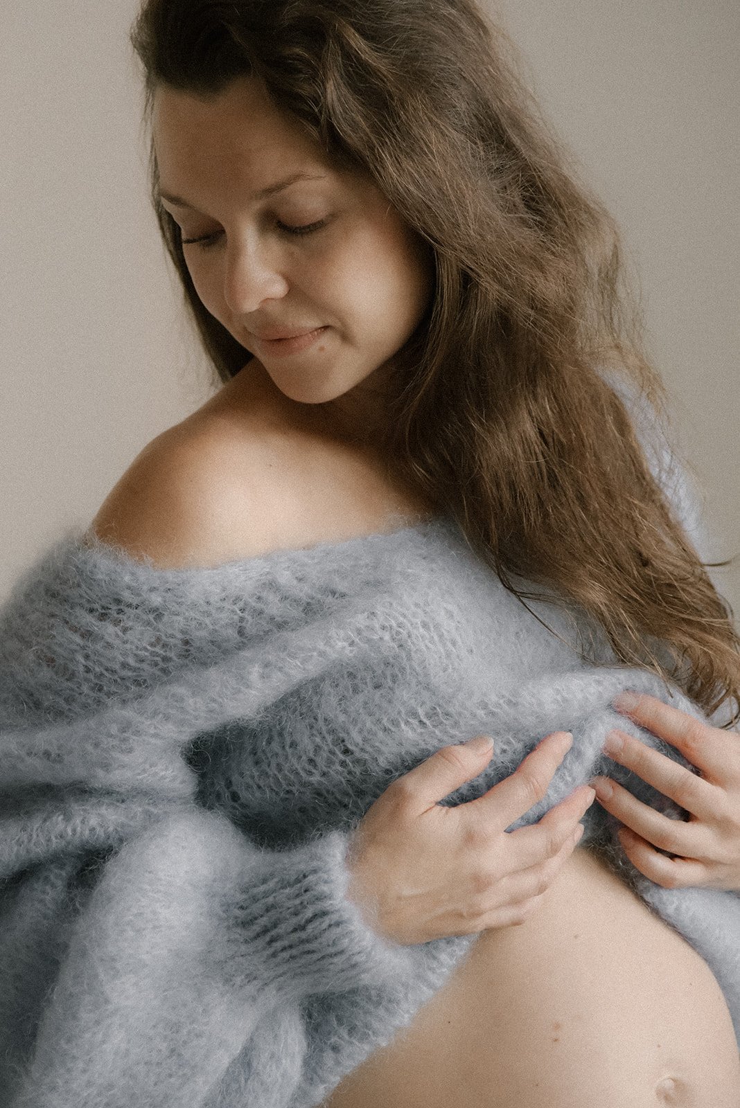 Lähikuva odottavasta äidistä. Raskauskuvaus studiolla.