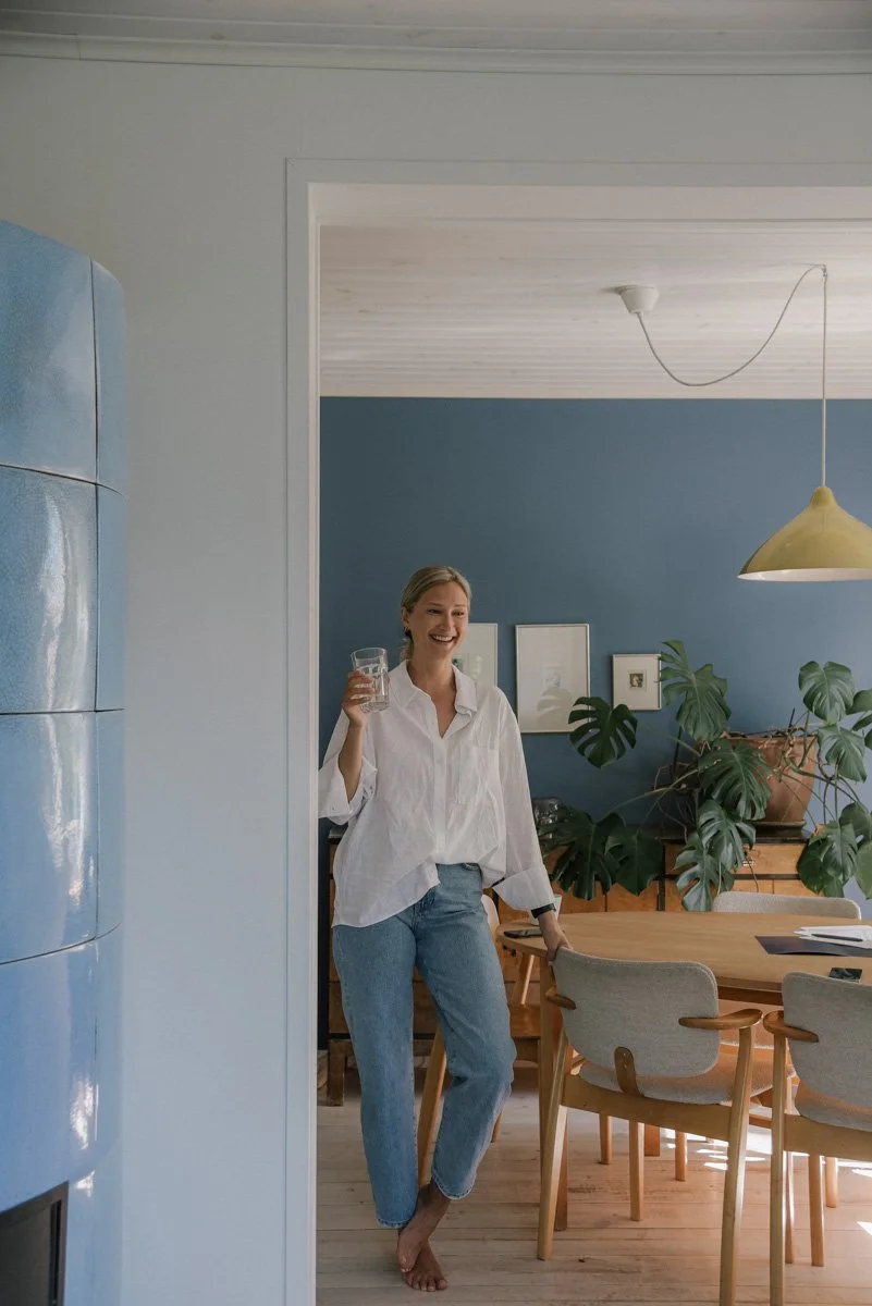 Neam Societyn brändikuvaus, yrittäjä katsoo hymyillen kameraan lasi kädessään.