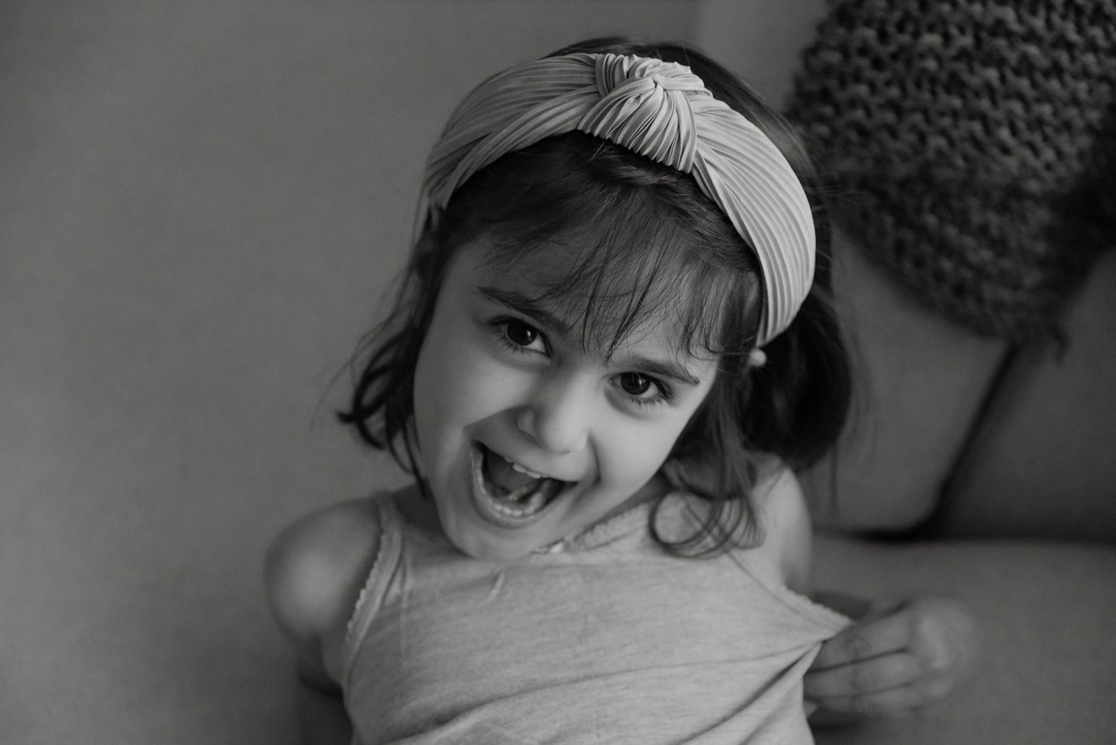 Mustavalkoisessa lähikuvassa tyttö. Lapsikuvaus kotona.