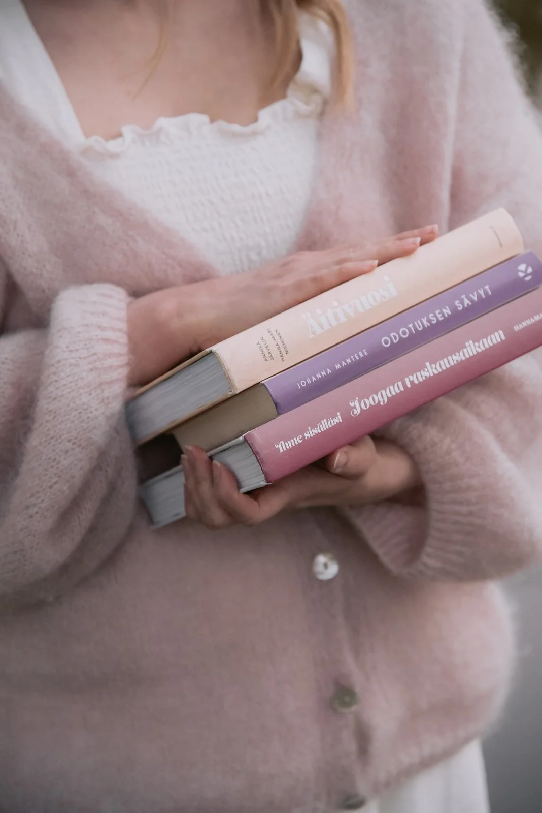 Yrityskuva, jossa doulalla sylissä kirjoja.