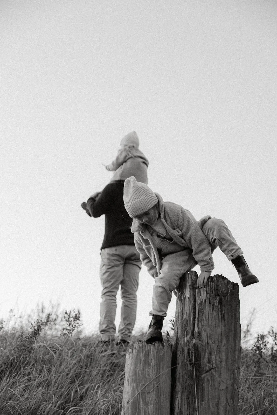 Kaksi lasta leikkii luontomaisemassa.