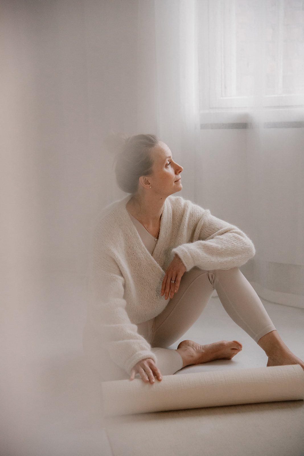 Vaumiin yrityskuvaus. Hyvinvointialan yrittäjä istuu joogahousuissaan  studion lattialla.