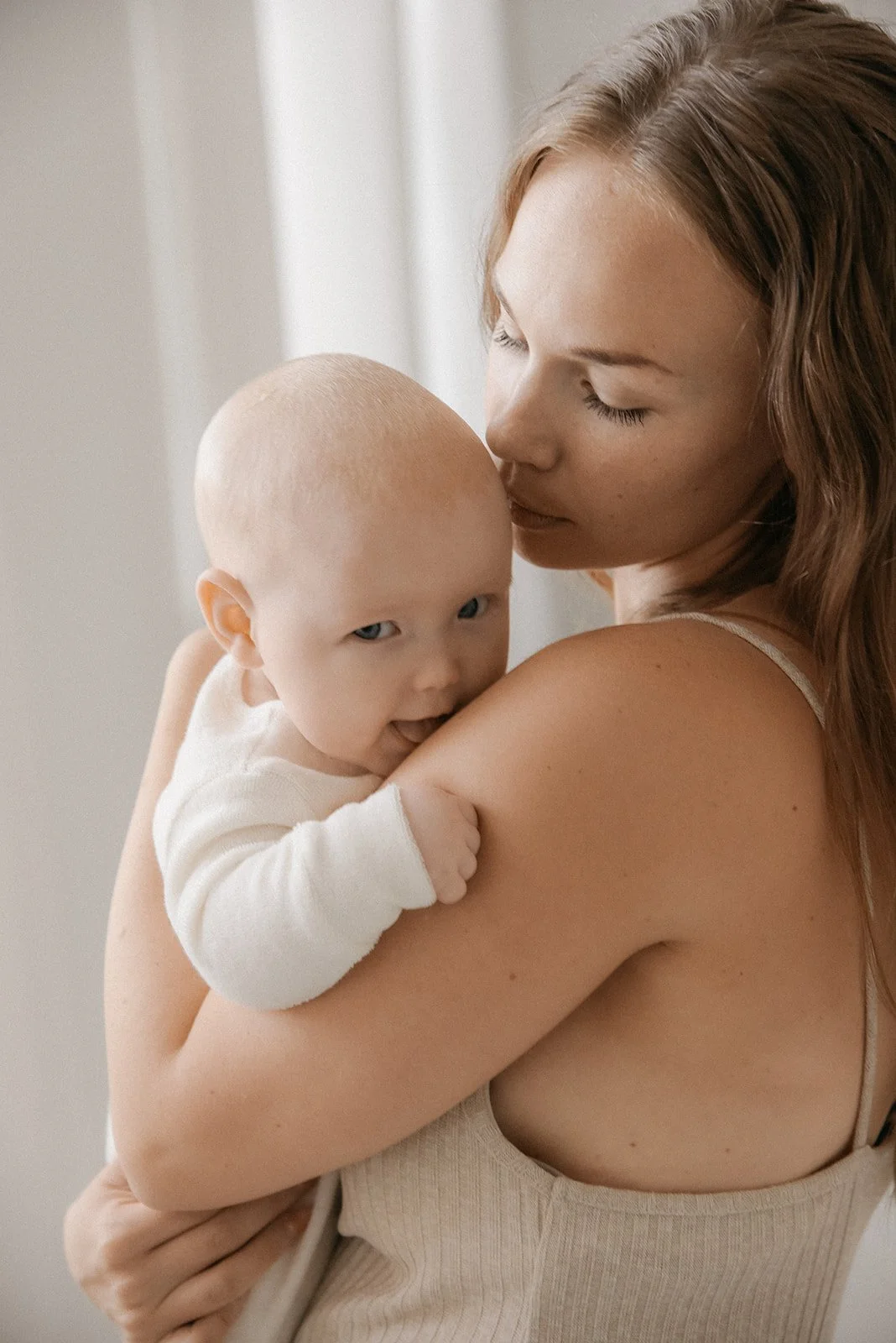 Äiti ja lapsi kuvattavana valoisalla studiolla.
