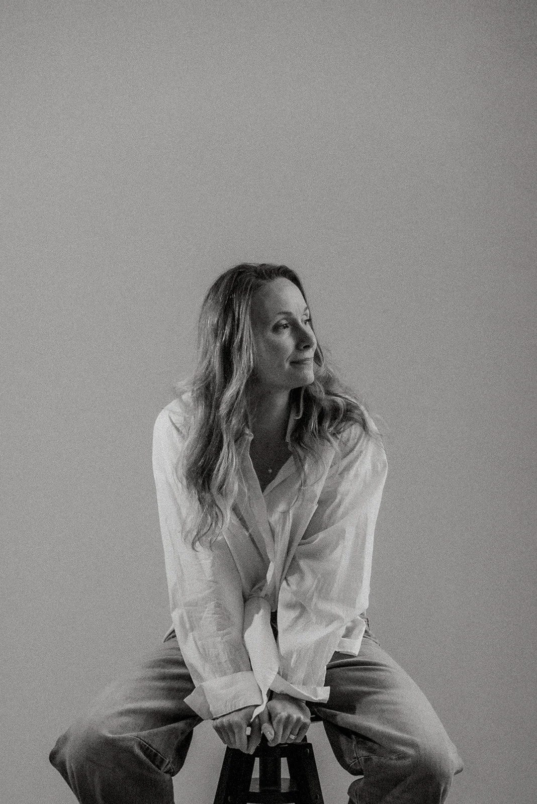 Mustavalkoisessa kuvassa Vaumiin yrittäjä istuu rauhallisesti studion tuolilla.