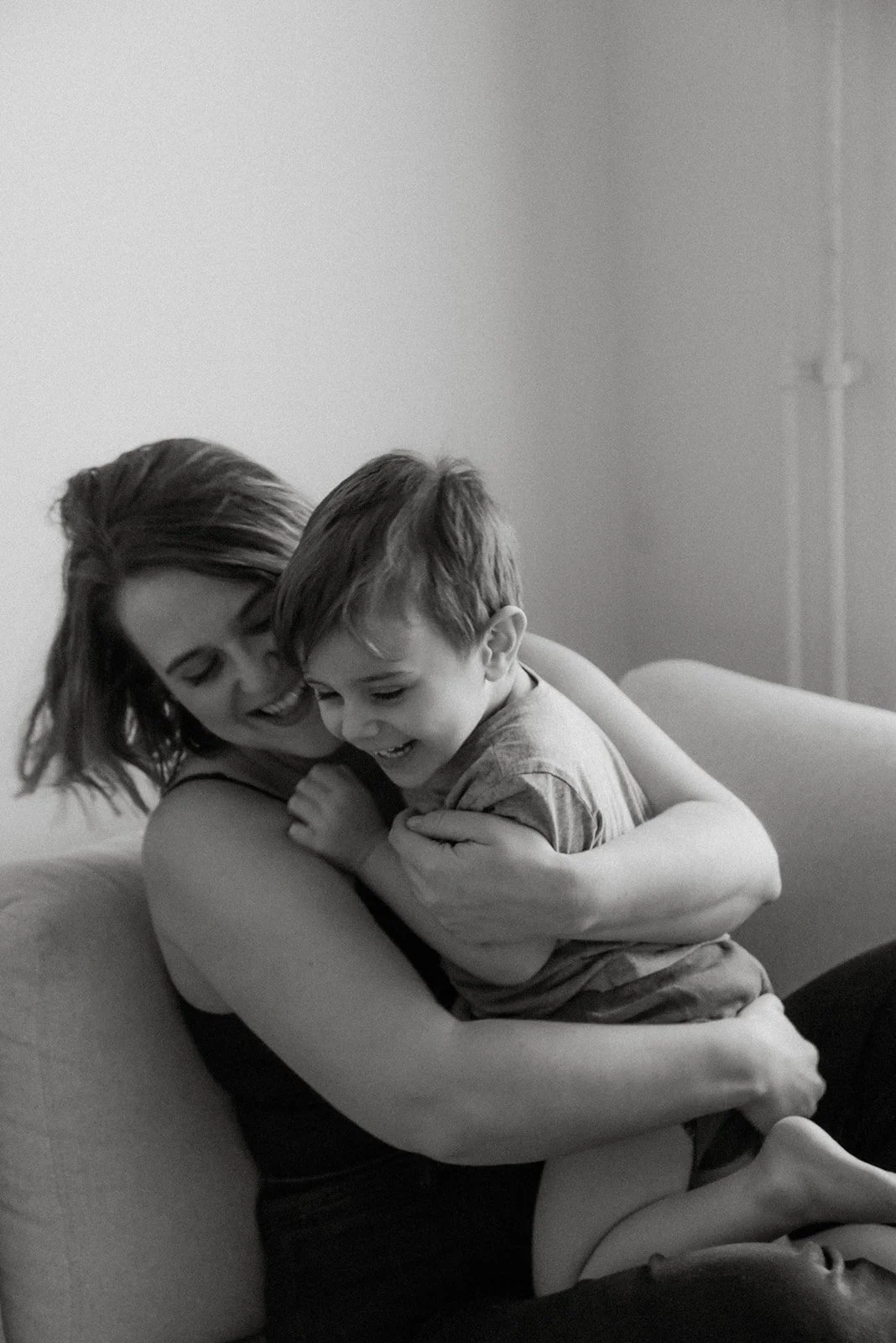 Iloinen äiti ja lapsi mustavalkoisessa kuvassa. Perhekuvaus Vantaa.