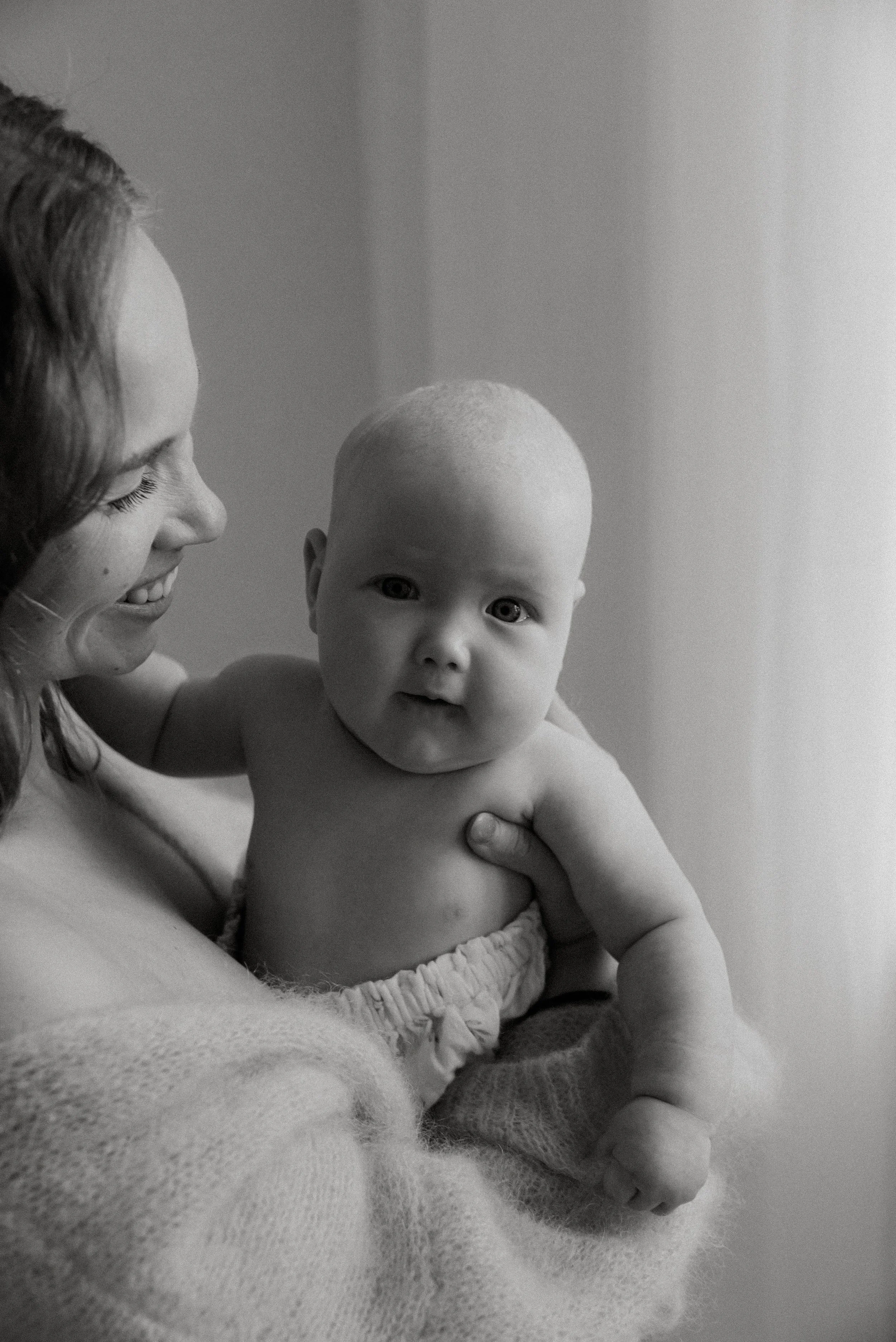 Lämmin hetki äidin ja lapsen välillä. Mustavalkoinen äiti-lapsikuva.