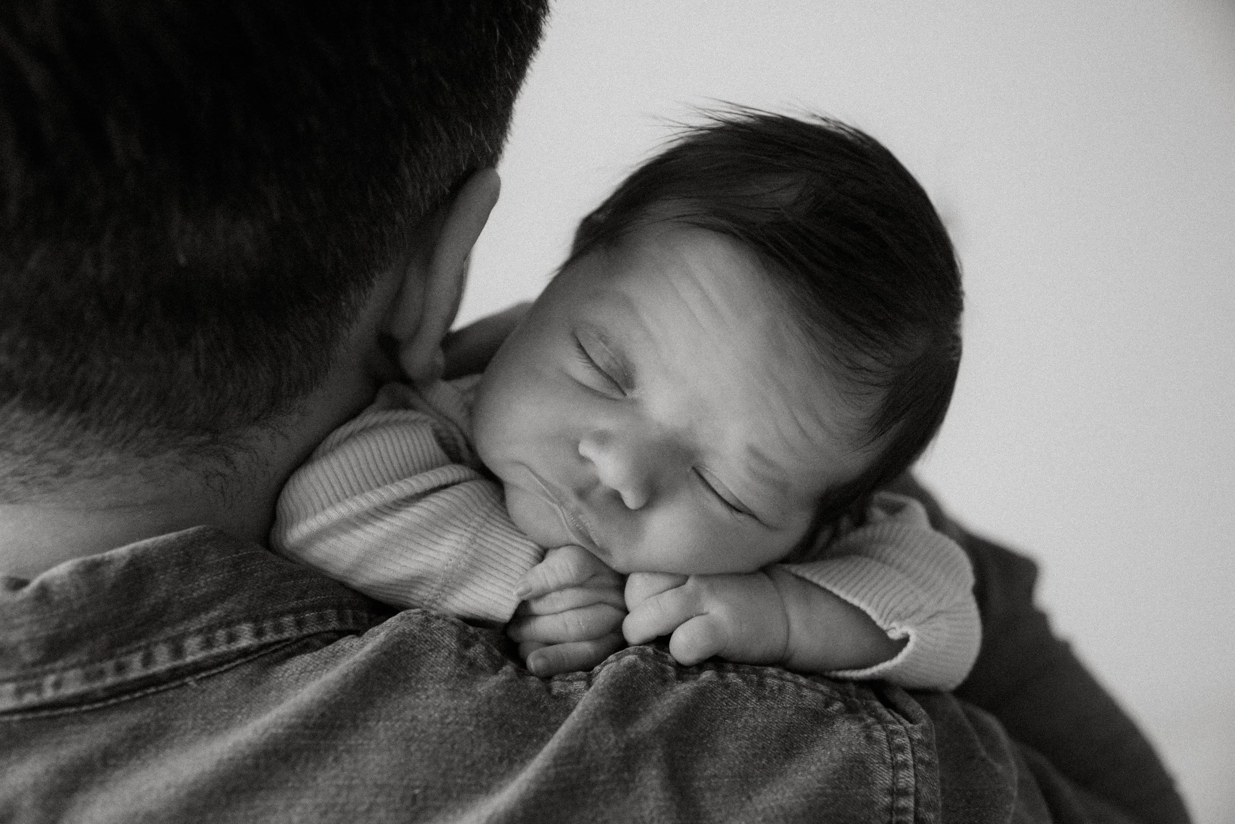 Vastasyntynyt vauva nukkuu sylissä. Vauvakuvaus Helsinki.