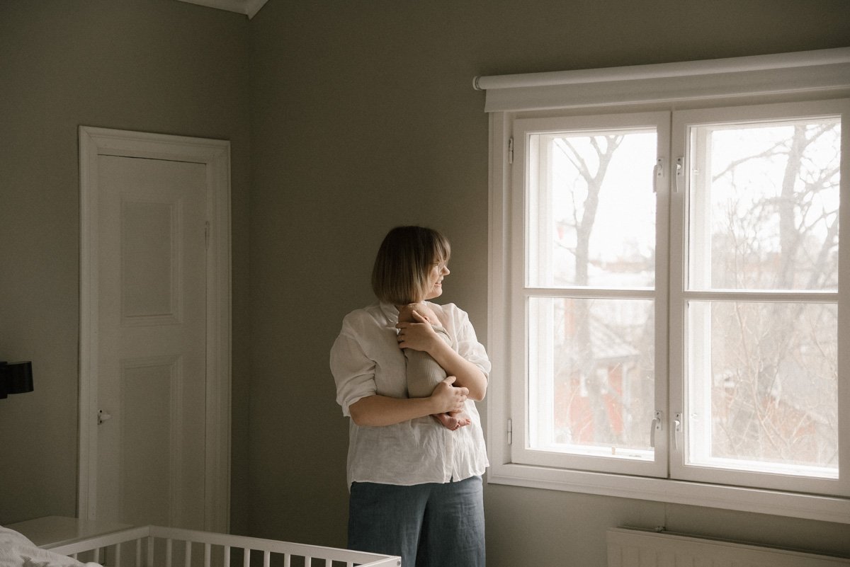 Äiti ja lapsi kodin makuuhuoneessa. Vauvakuvaus kotona.