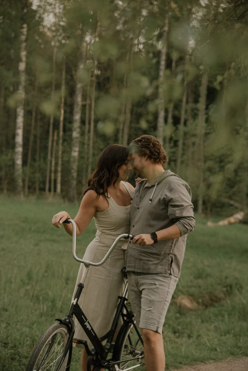 Pariskunta ja pyörä vehreän maiseman keskellä. Valokuvaaja Heidi Väisänen.