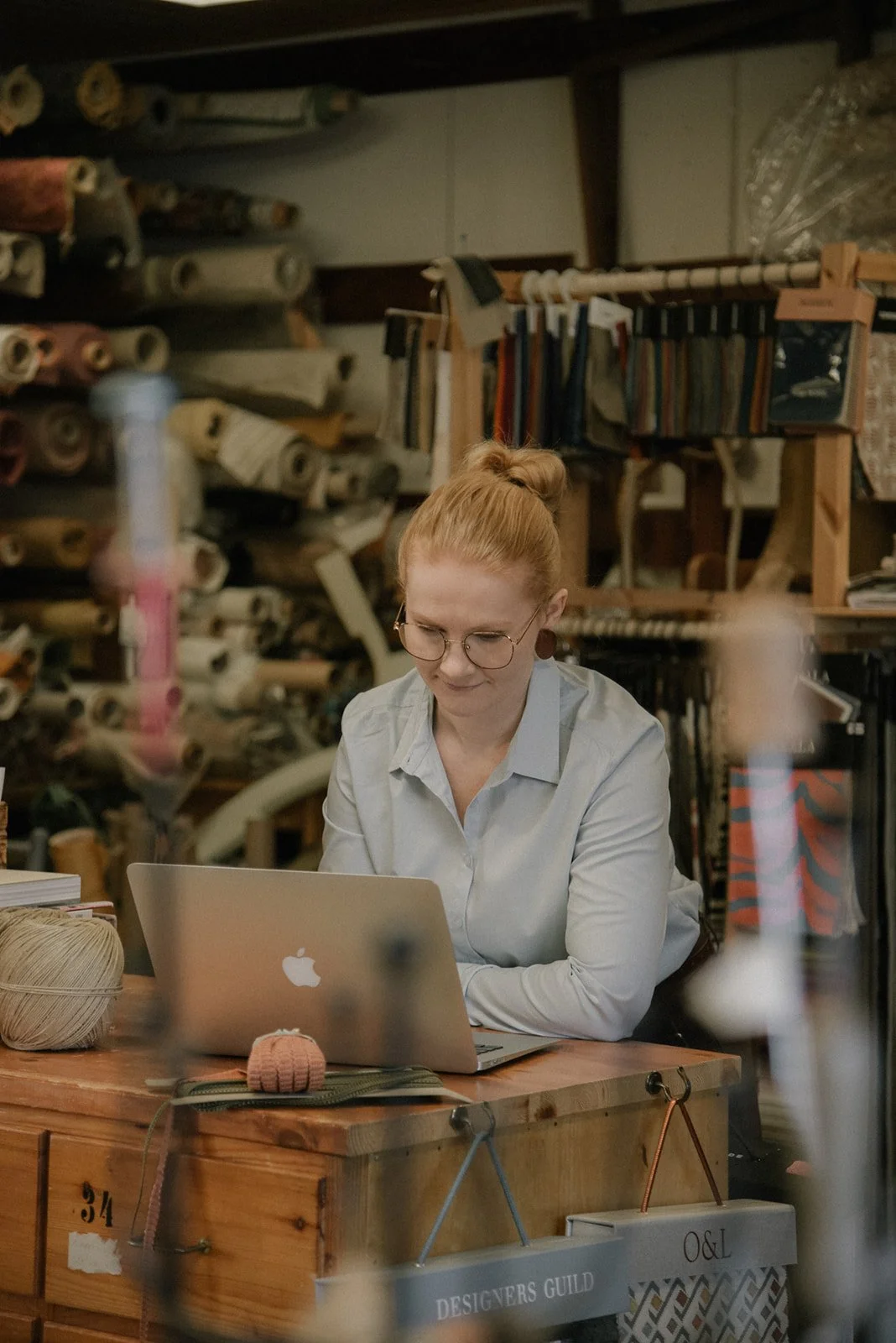 Yrittäjä naputtelee tietokonetta brändikuvassa.
