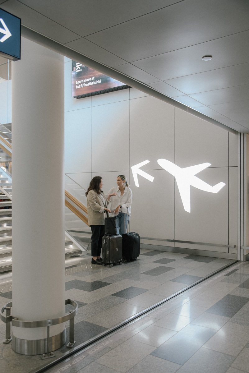 Neam Societyn brändikuva. Naisyrittäjät juttelevat lentokentän aulassa.