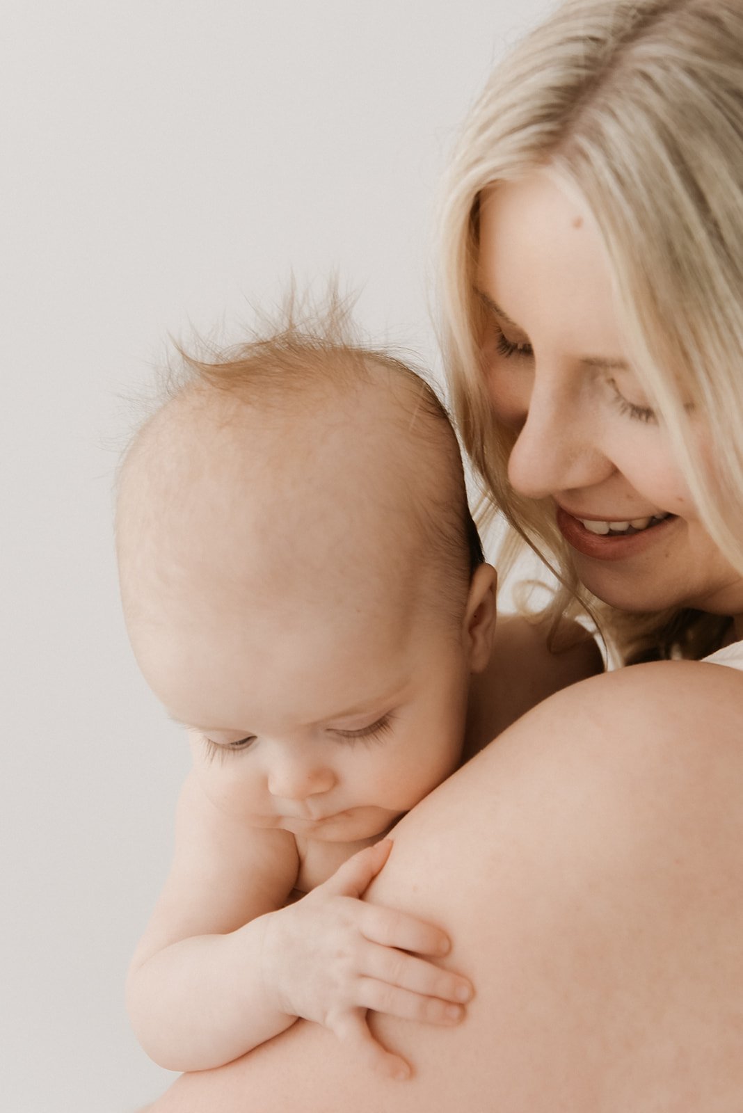 Valoisa kuva äidista ja vauvasta.