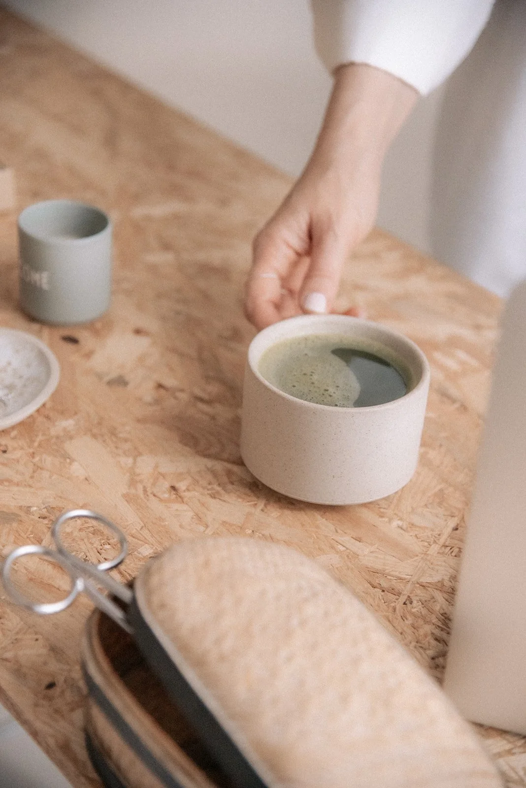 Heartiven brändikuvaus studiolla, yrittäjä nostaa pöydältä teekuppia.