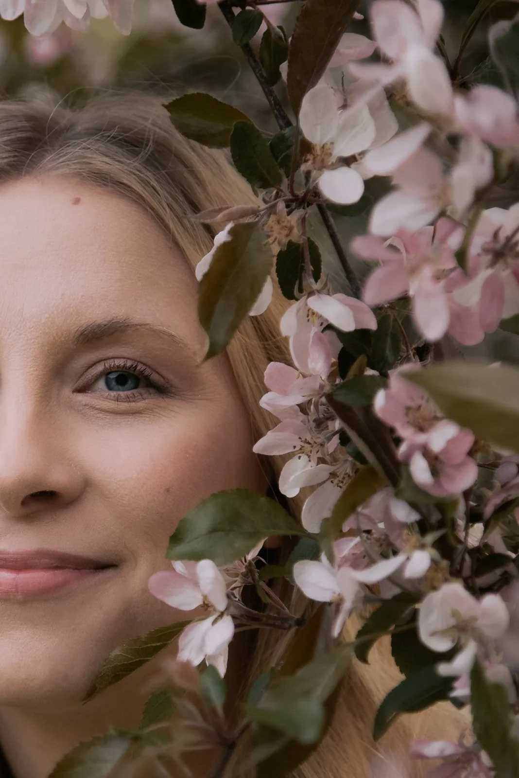 Henkilökuva doula Jutta Alasesta kirsikkapuun katveessa.