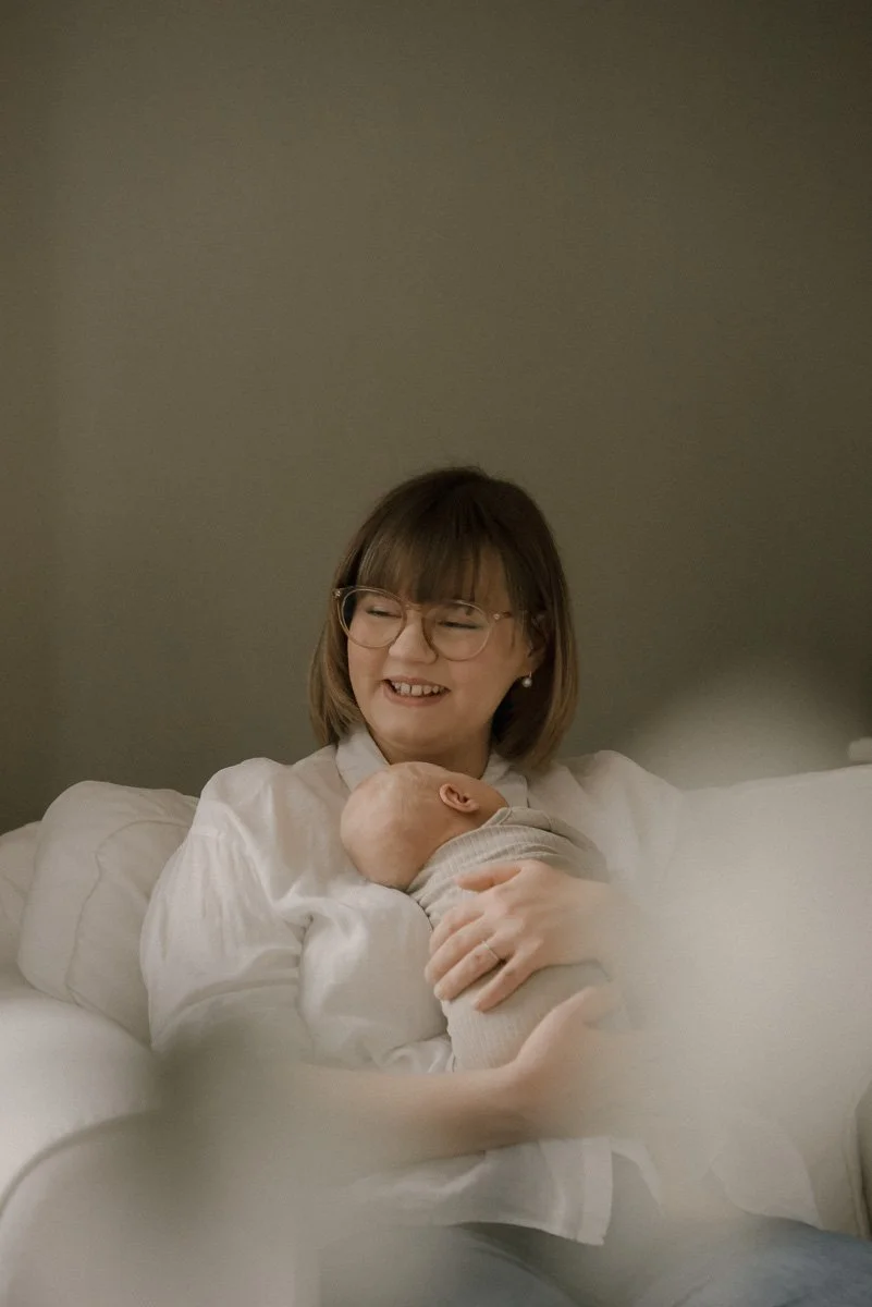 Äidin hellä syli vastasyntyneelle. Vauvakuvaus Helsinki.