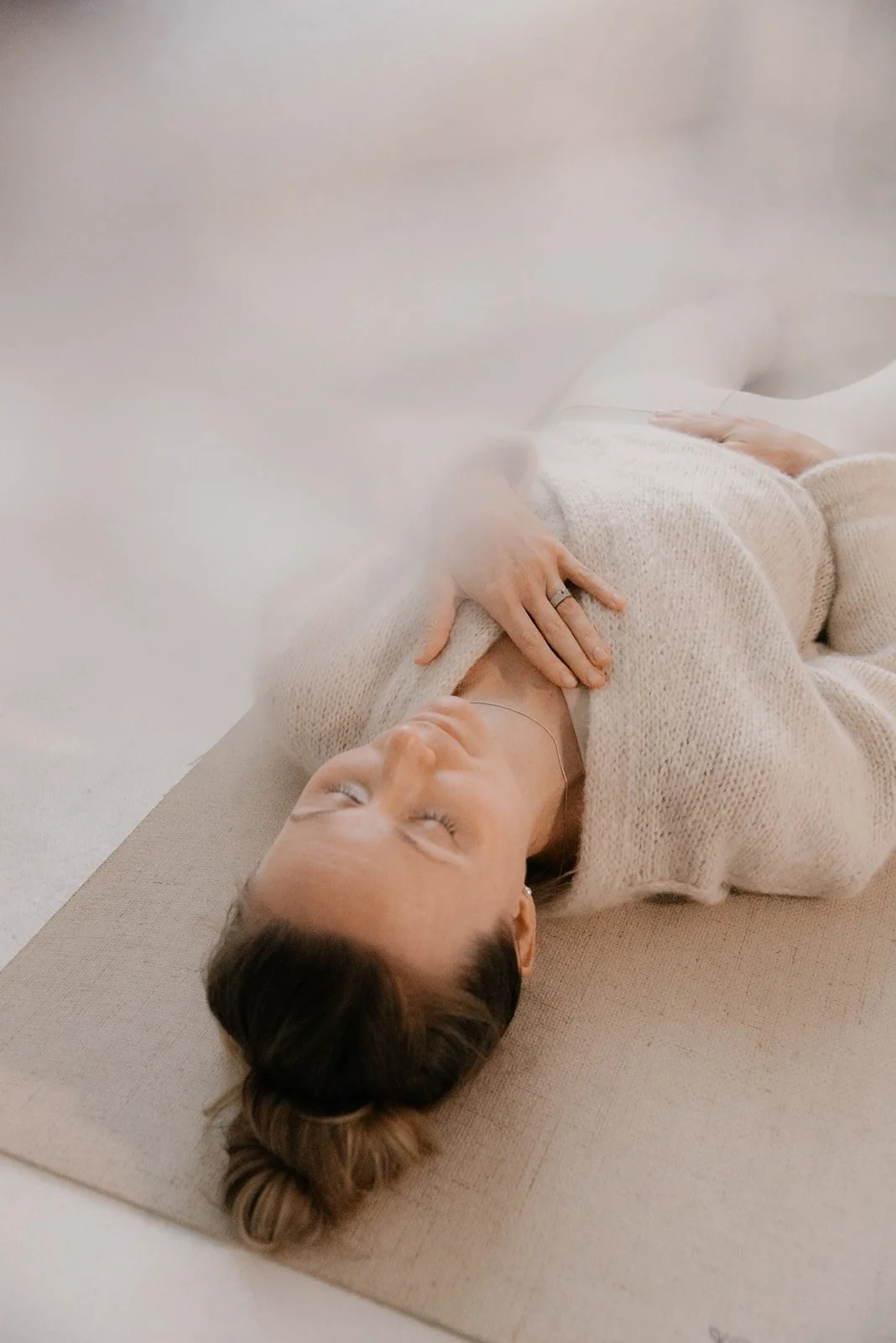 Rentoutunut naisyrittäjä makaa joogamatollaan ja rentoutuu. Vaumiin brändikuvaus, kuvannut Heidi Väisänen.