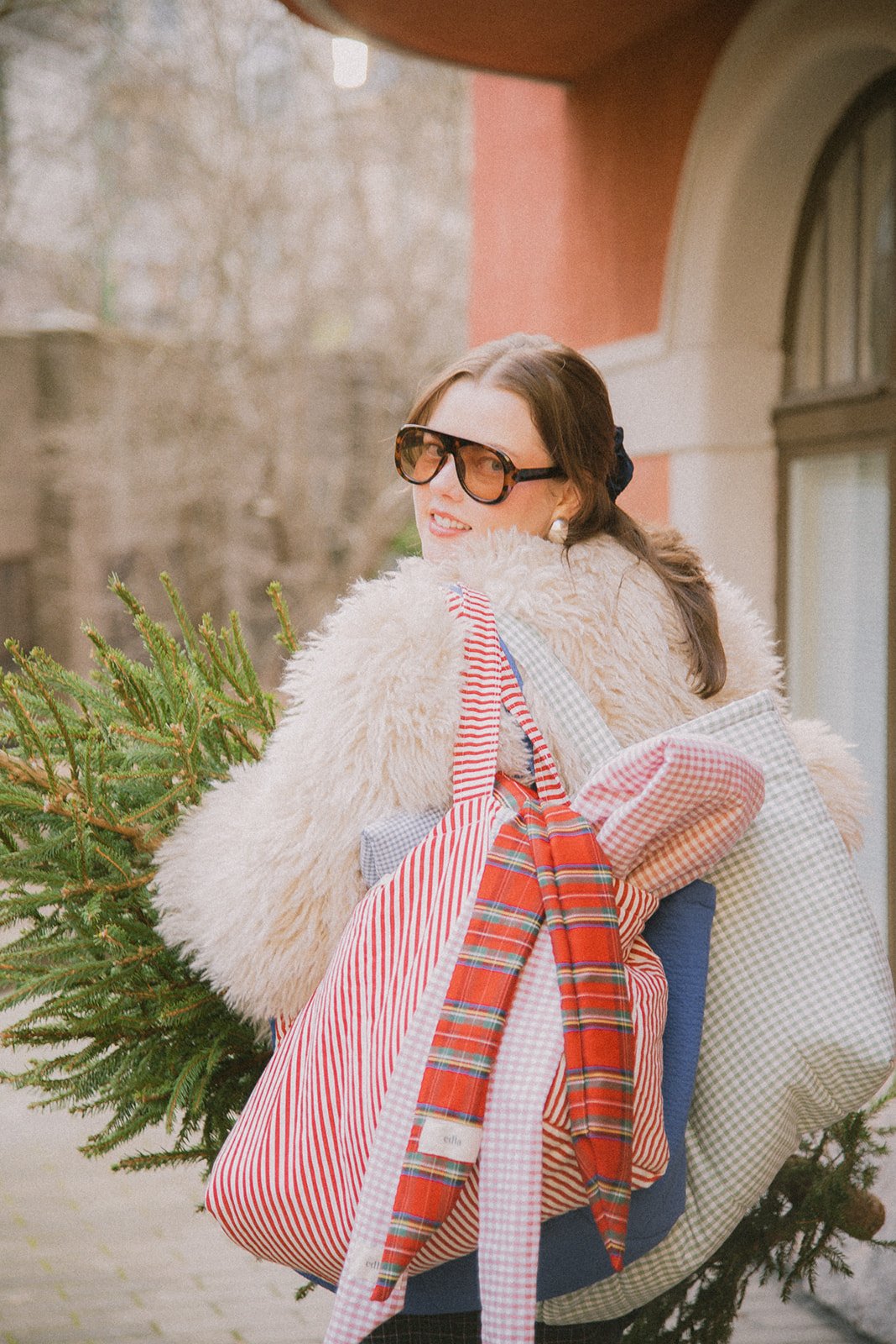 Edlan brändikuvaus kaupunkimiljöössä. Yrittäjä kävelee kadulla brändin kassit olallaan.