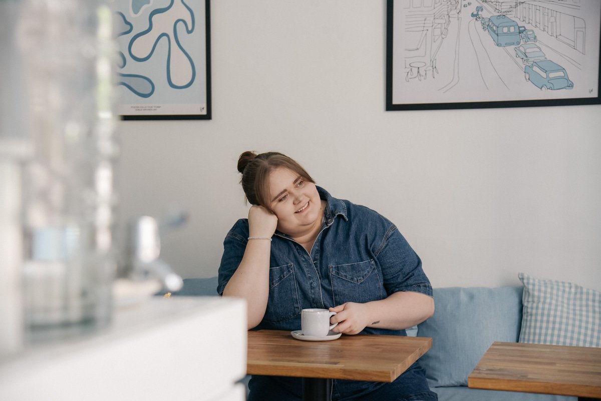 Bakerikan brändikuvaus, iloinen naisyrittäjä katsoo ulos ikkunasta.