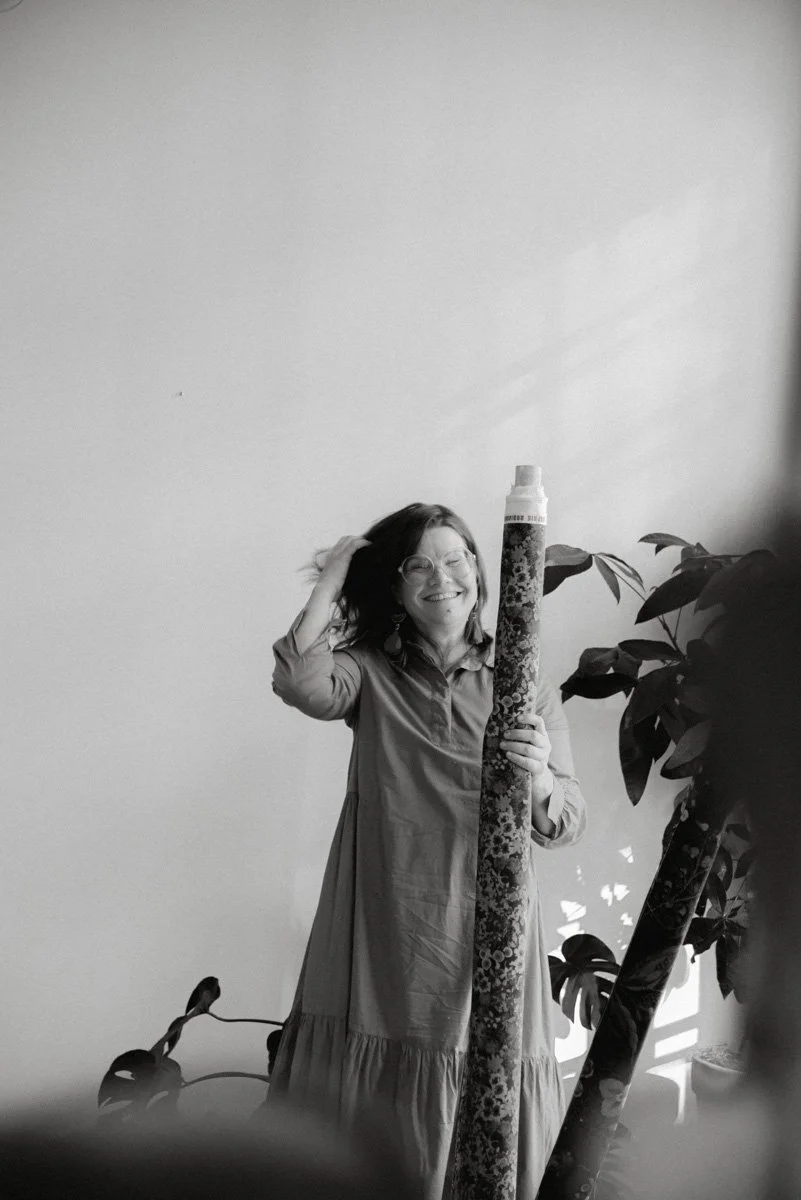 Verhoomoyrittäjä Virve työssään, pitelee käsissään kangasrullaa. Kuvannut henkilökuvaaja Heidi Väisänen.