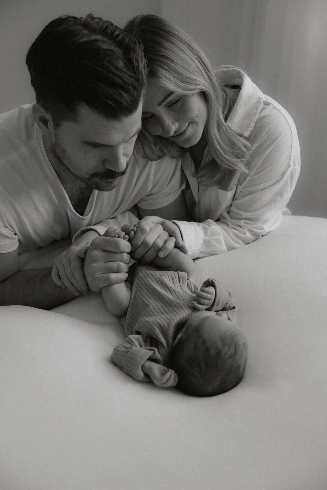 Ylpeät vanhemmat katselevat pienokaistaan. Vastasyntyneen ensi hetket on taltioinut vauvakuvaaja Heidi Väisänen.