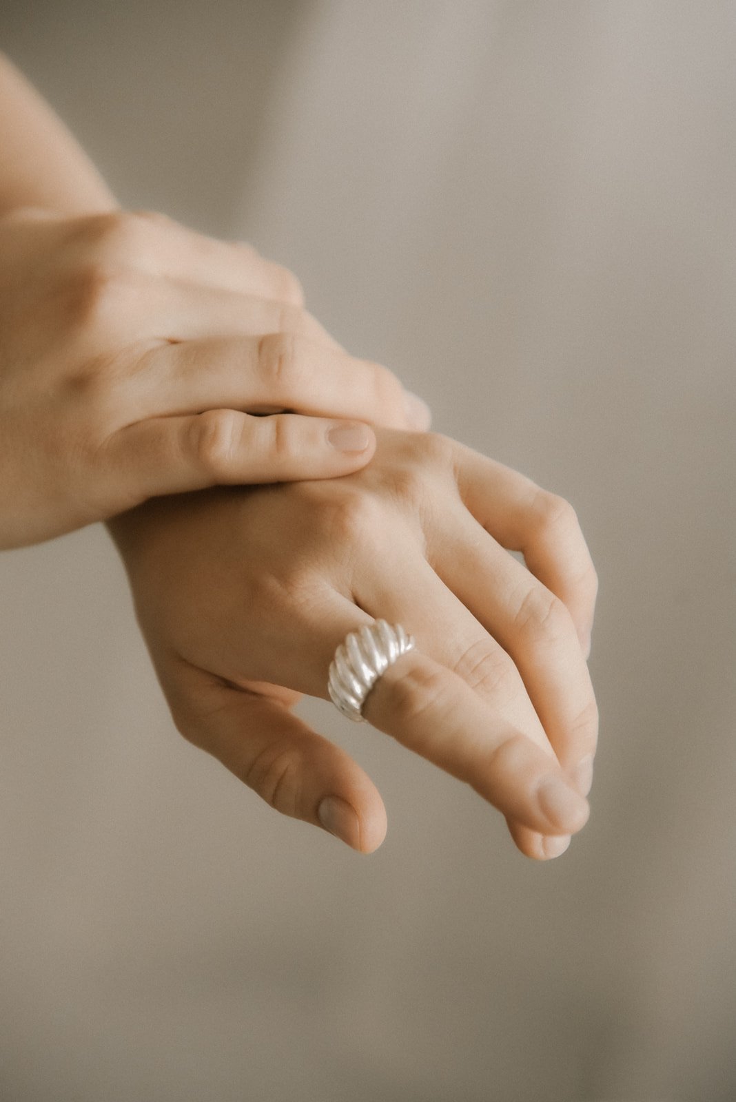 Harmoninen tuotekuva, jossa kaunis sormus ja kädet.