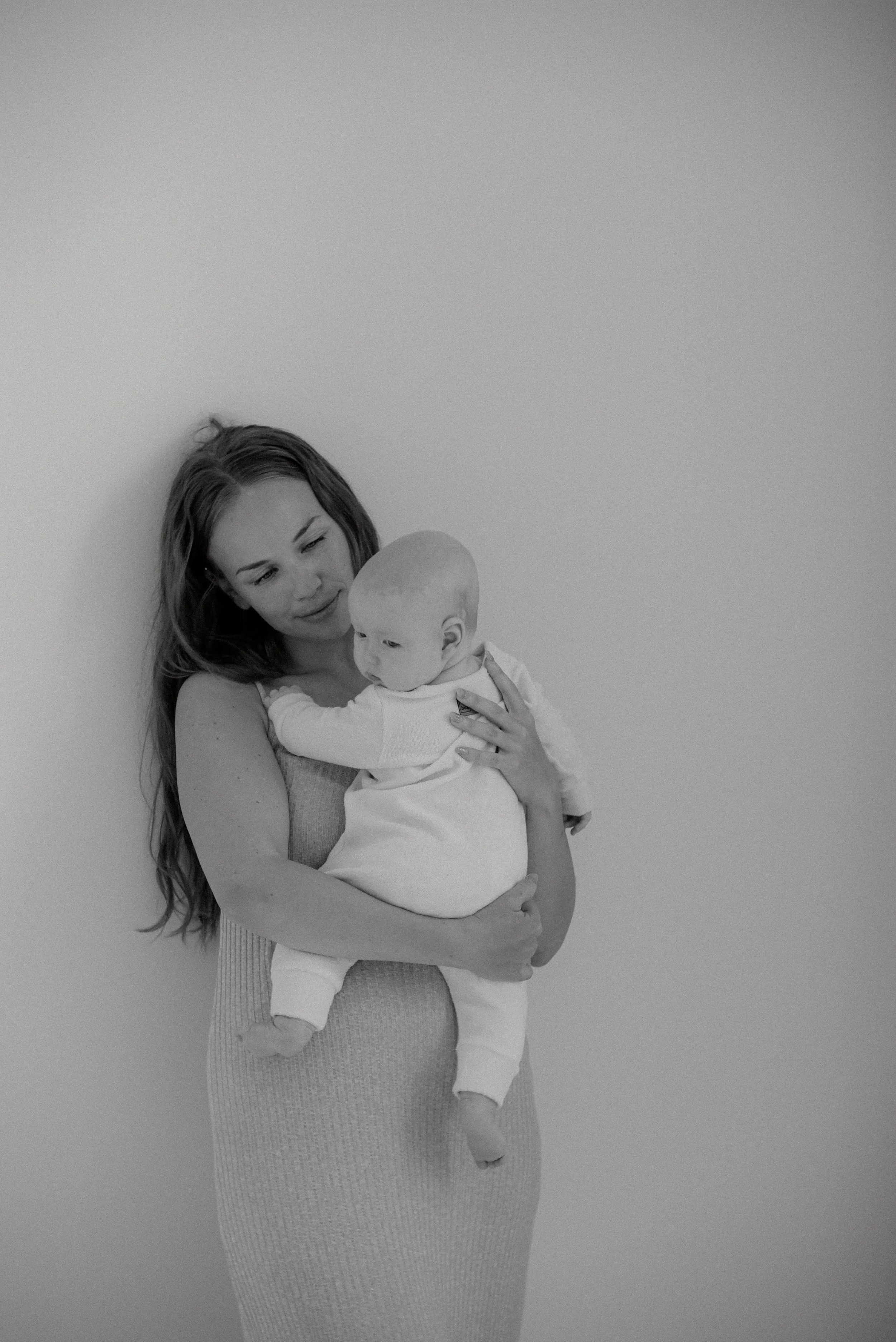 Vauva äidin sylissa äiti-lapsivalokuvauksessa studiolla.