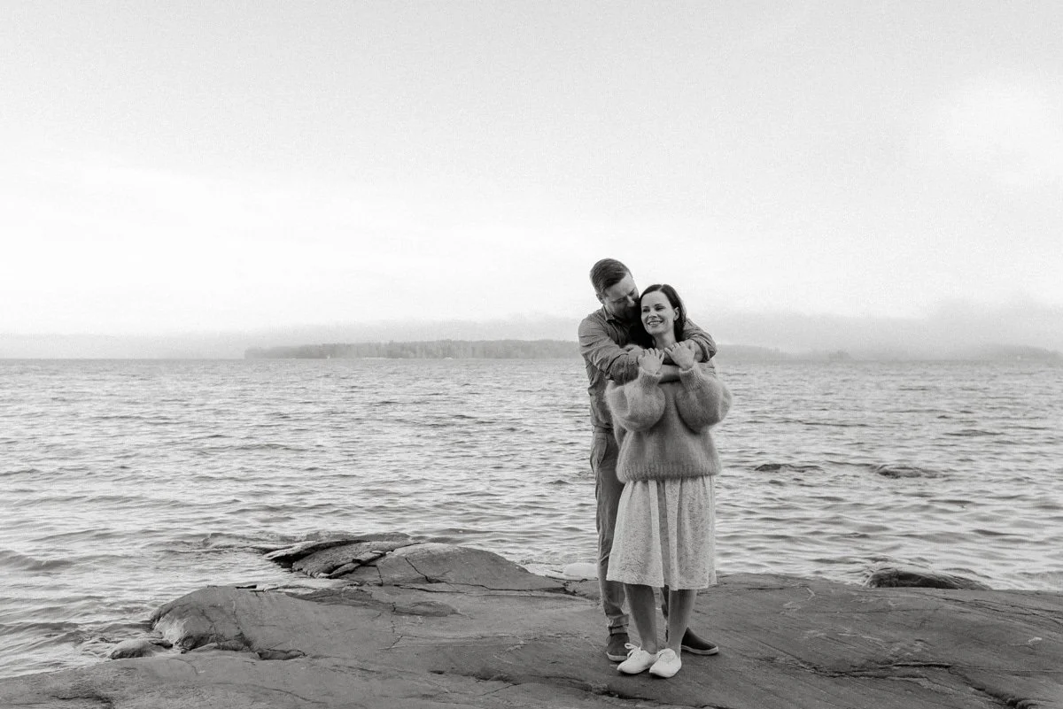 Perhekuvaus Espoo, halaava pariskunta seisooo rantakallioilla.