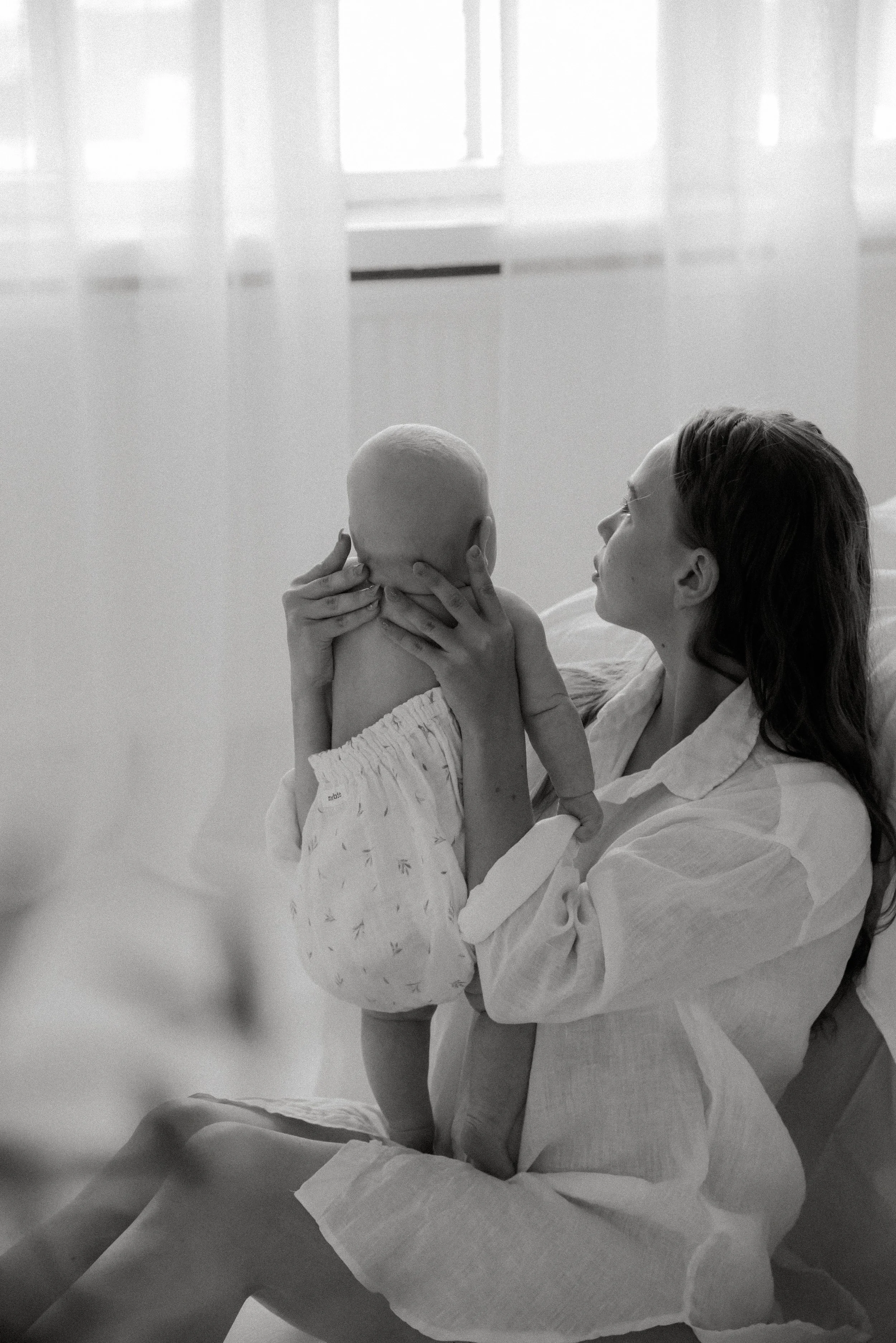 Lämmin hetki äidin ja lapsen välillä. Äiti- ja lapsikuvaus studiossa.