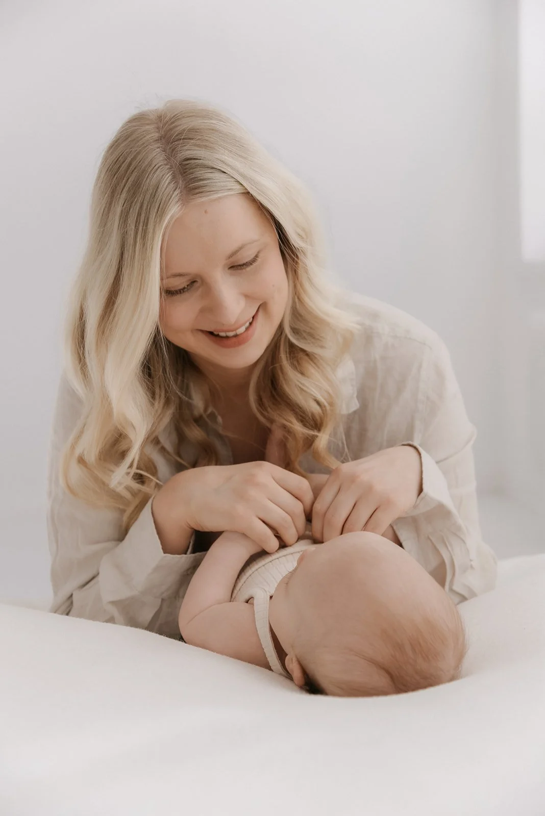 Äiti ja vauva katselevat toisiaan. Äiti-lapsikuvaus studiolla.