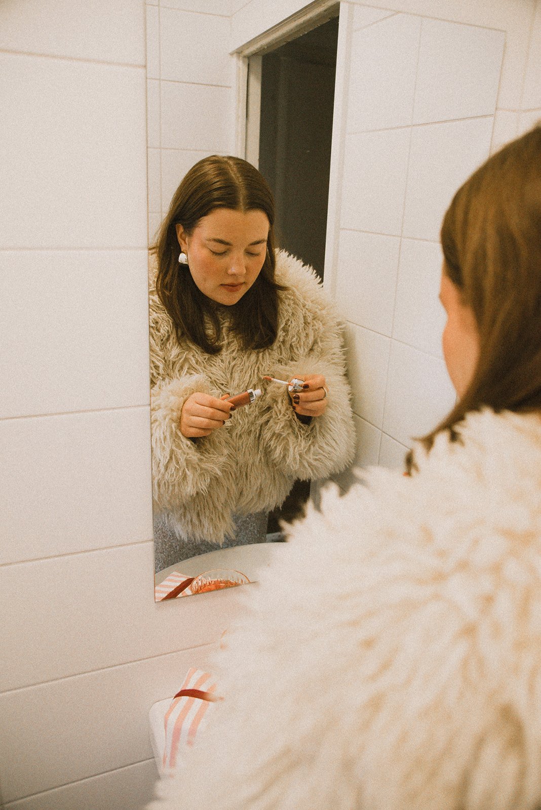 Edlan yrittäjä meikkaa kylpyhuoneessa.