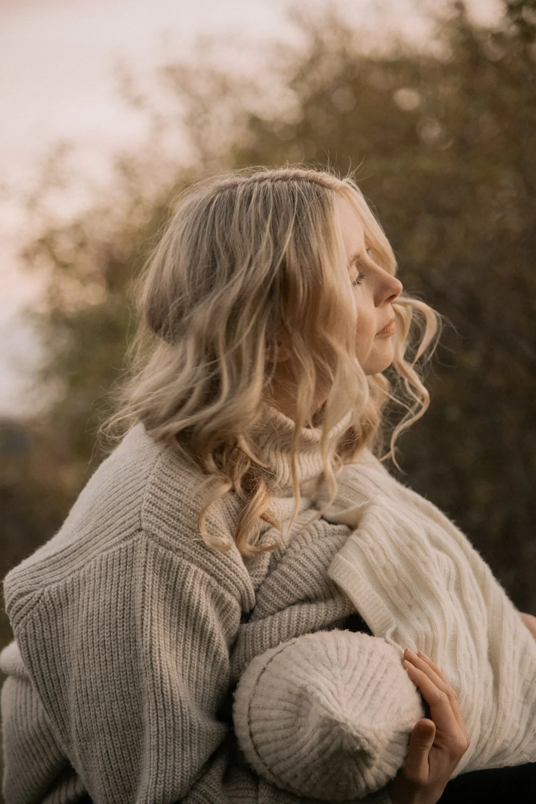 Perhekuvaus Espoo, äiti halaa vauvaa sylissään.