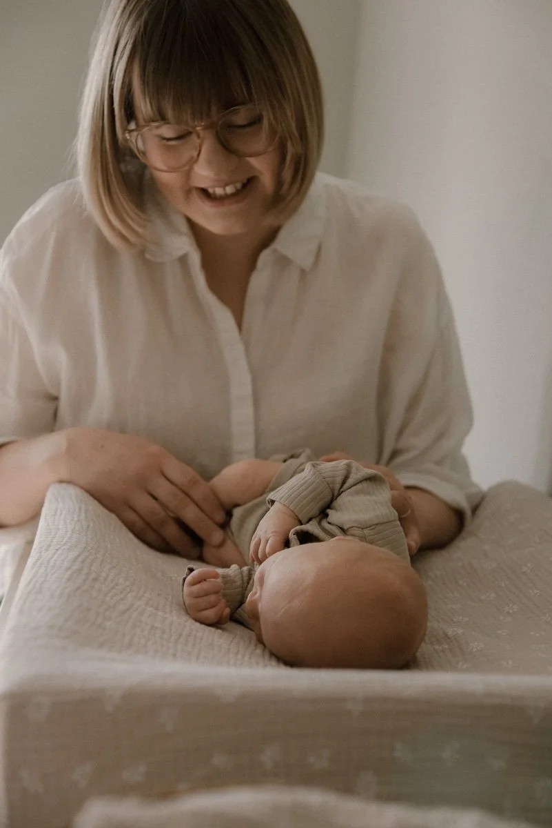Vauva hoitopedillä äidin hoidettavana. Vauvakuvaus kotona.