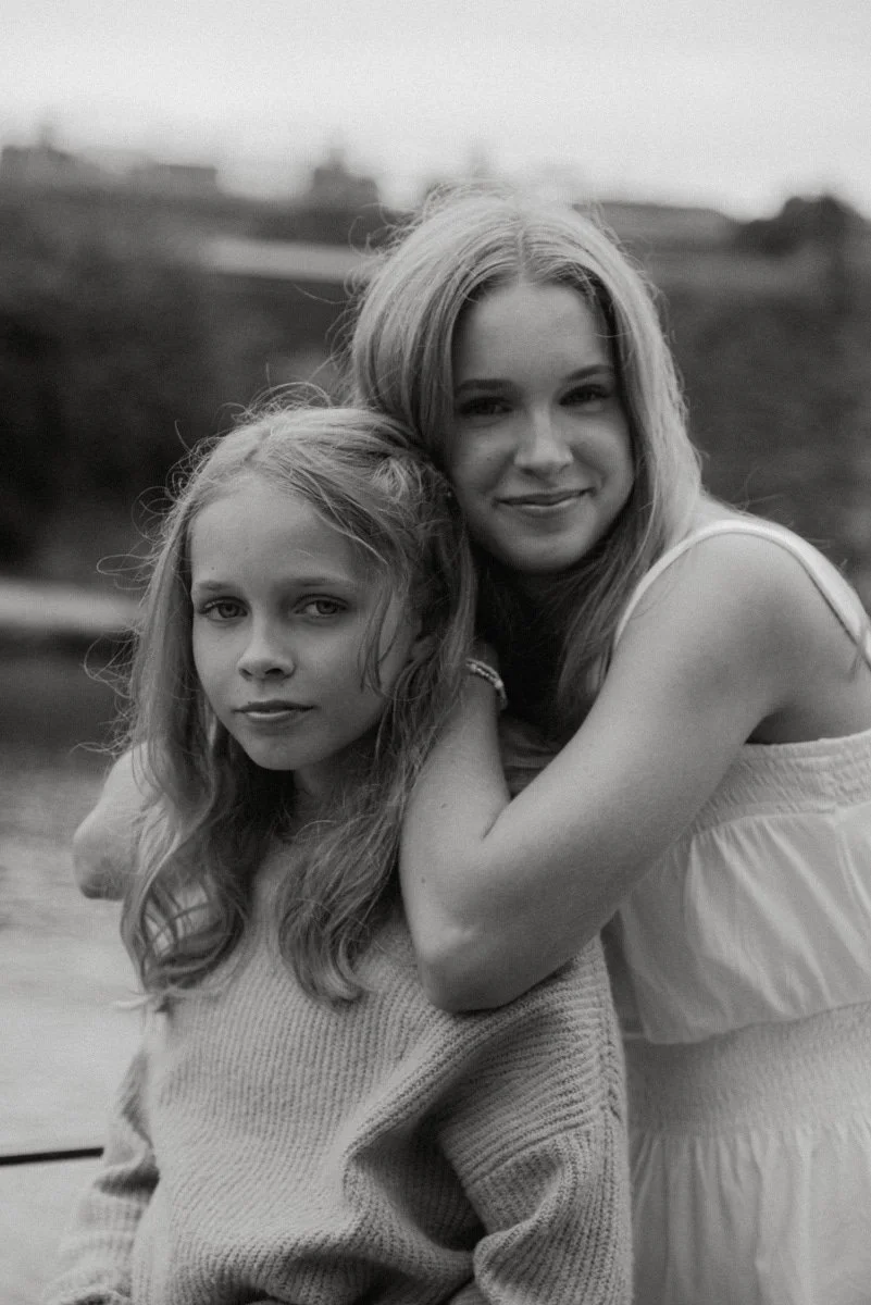 Mustavalkoinen sisaruskuva. Kaksi lasta katsoo hymyillen kameraan.