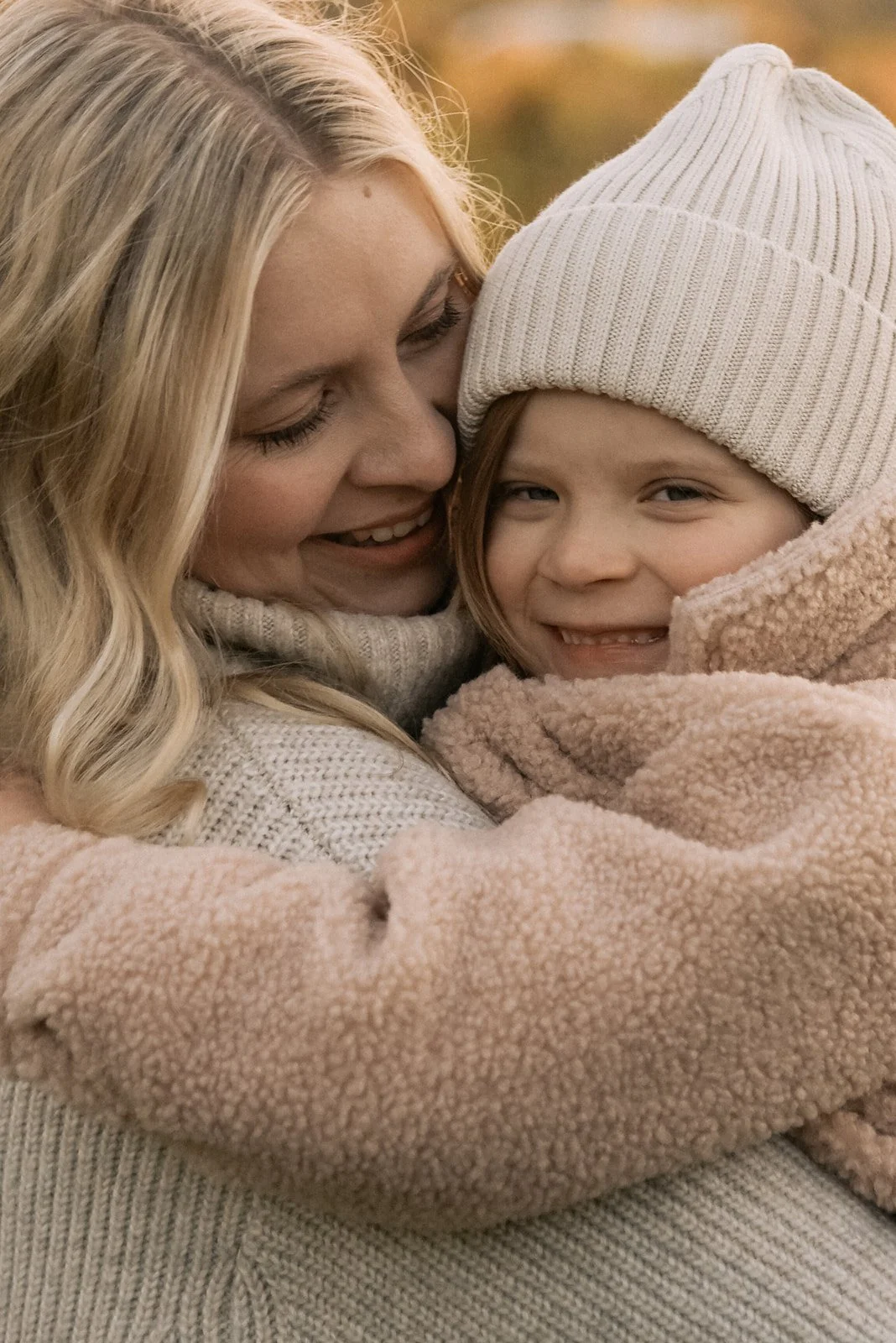 Perhekuvauksessa äiti syleilee tytärtään.