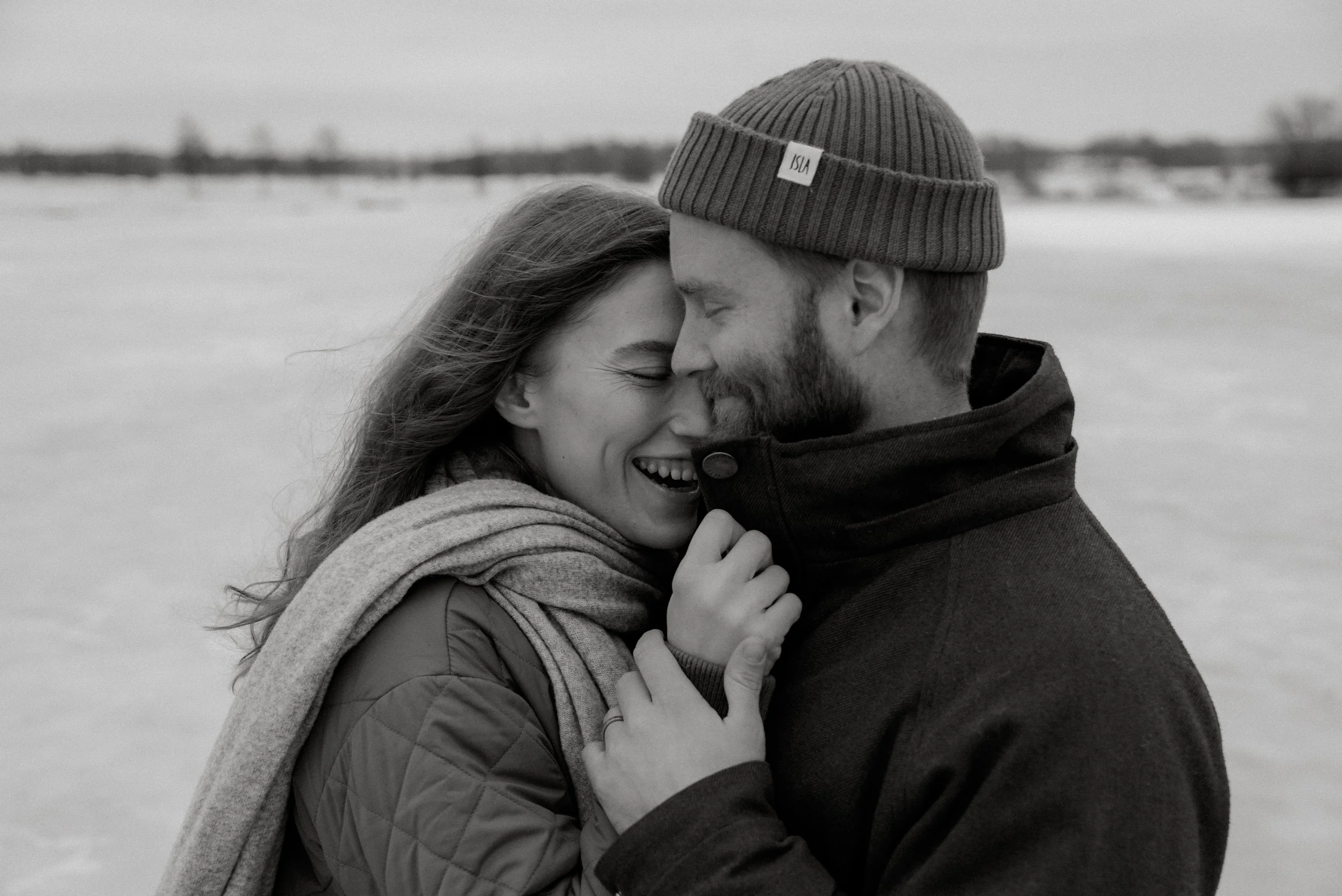 Pariskuntakuvaus, jossa iloinen pari jäällä.