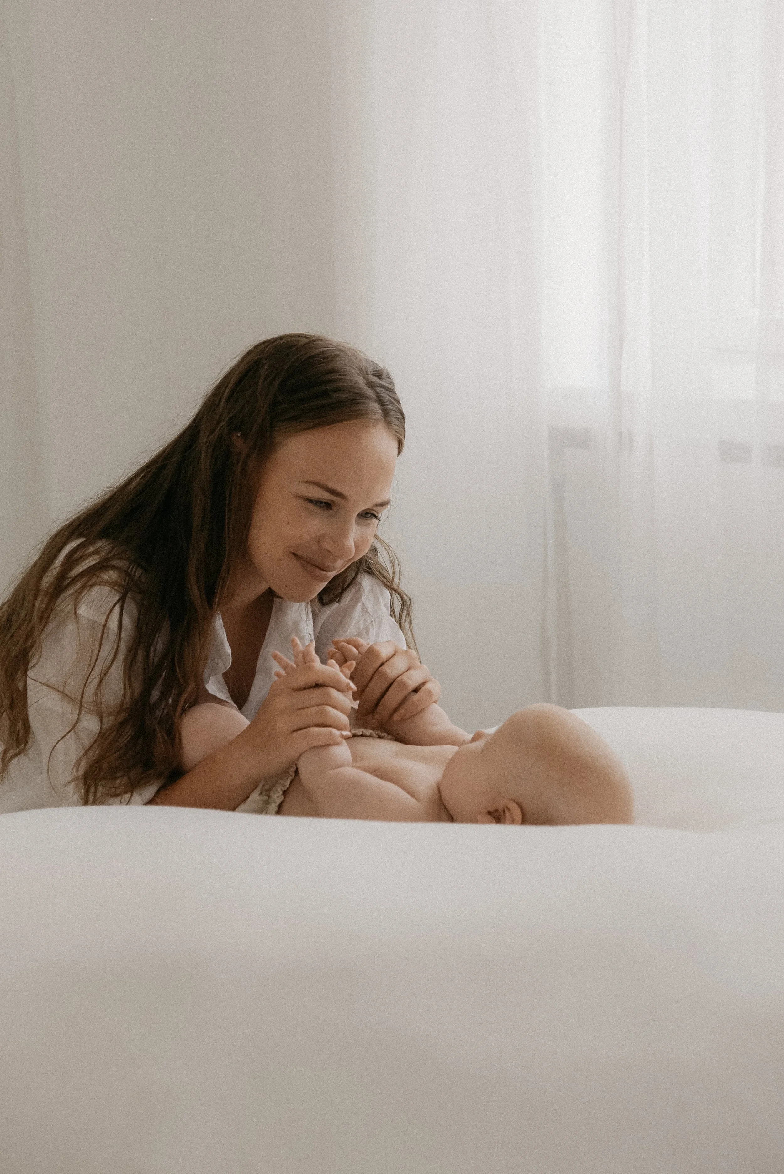 Hellä ja lämmin äidin kosketus. Äiti- ja lapsikuvaus studiossa.