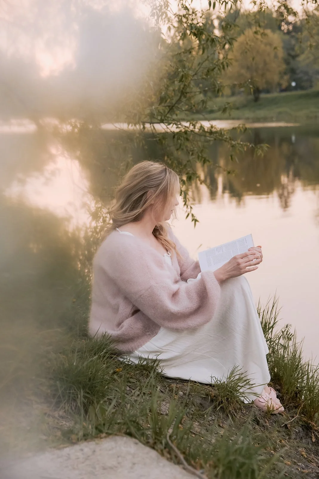 Yrityskuvaus luontomaisemassa. Naisyrittäjä lukee kirjaa seesteisessä miljöössä.