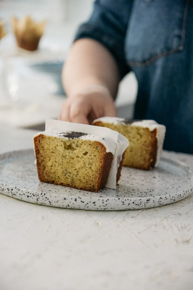 Yrittäjä asettelee kakkupaloja lautaselle kahvilassaan Helsingissä. Kuvannut brändikuvaaja Heidi Väisänen.