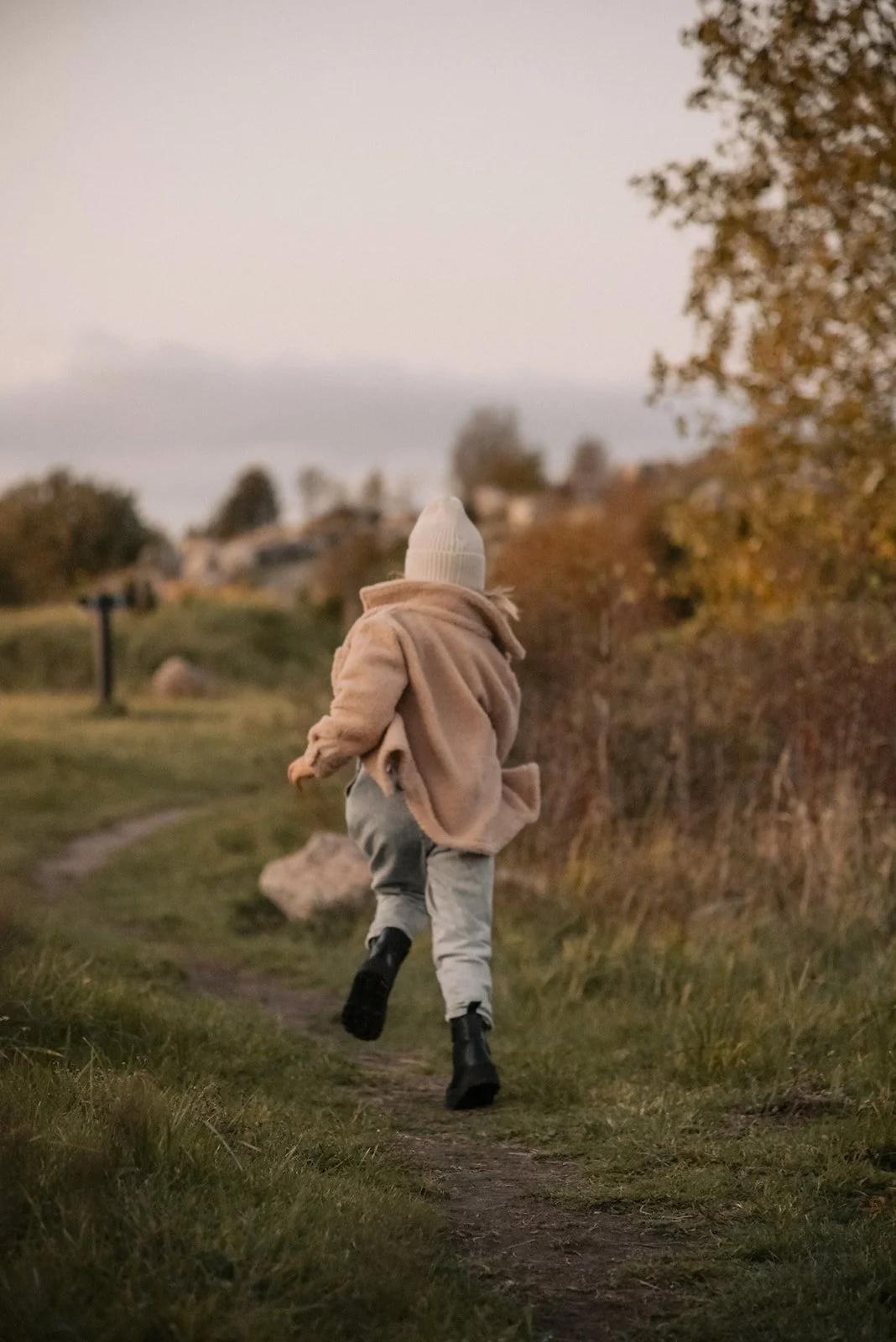 Luonnossa juokseva pieni lapsi.