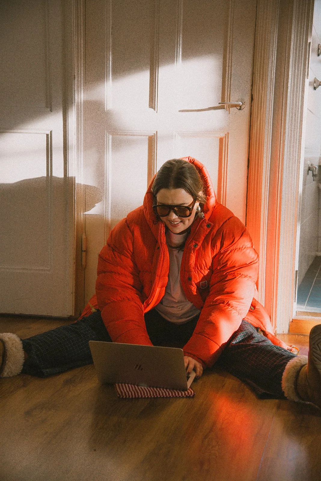 Edlan brändikuvaus, yrittäjä istuu lattialla ja näpyttelee tietokonetta.