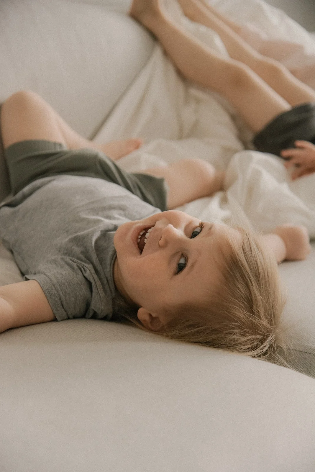 Iloiset lapset leikkivät rennosti kotonaan. Sisarkuvaus kotona.