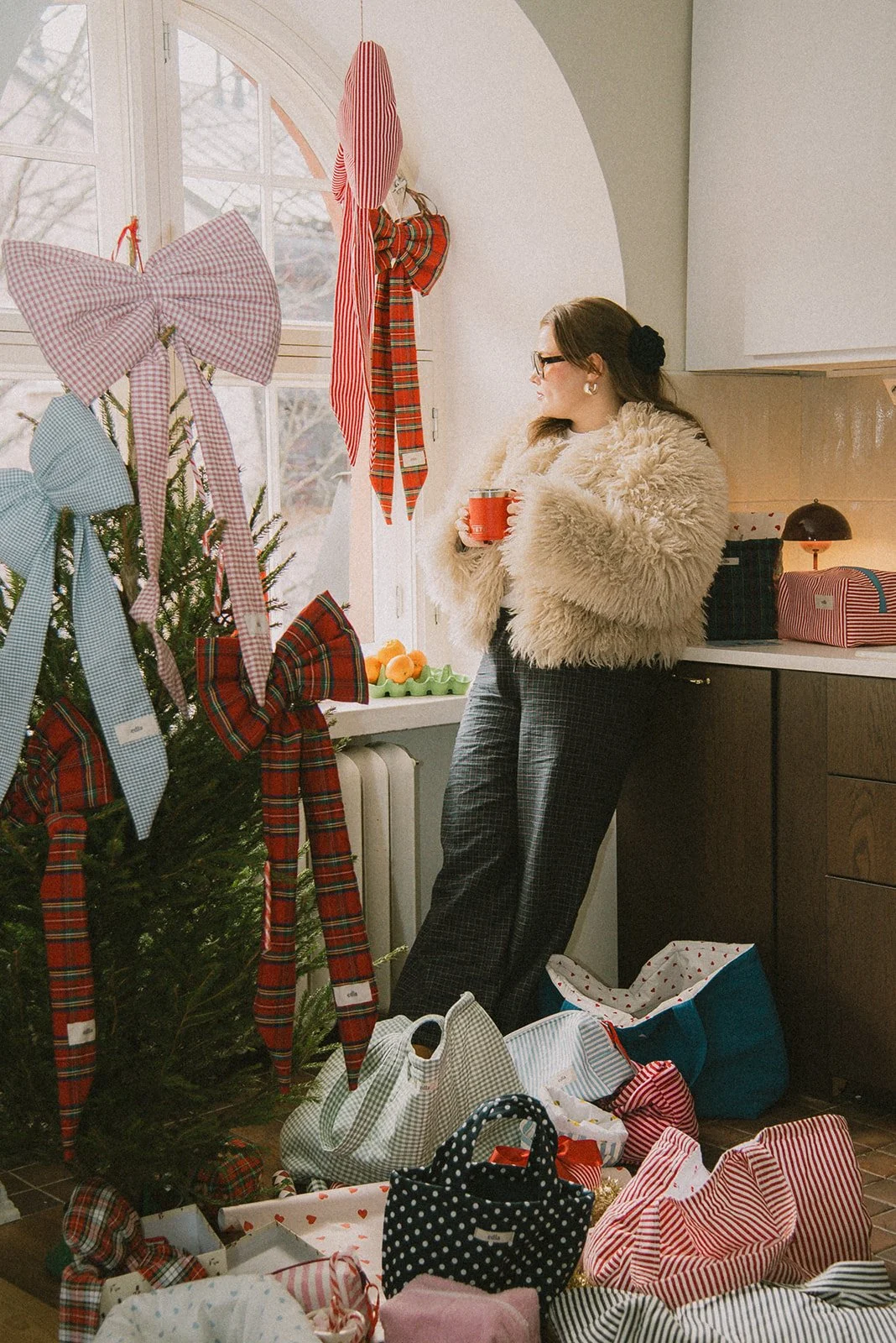 Edlan yrityskuvaus, yrittäjä seisoo brändin tuotteiden keskellä joulukuusen vieressä.