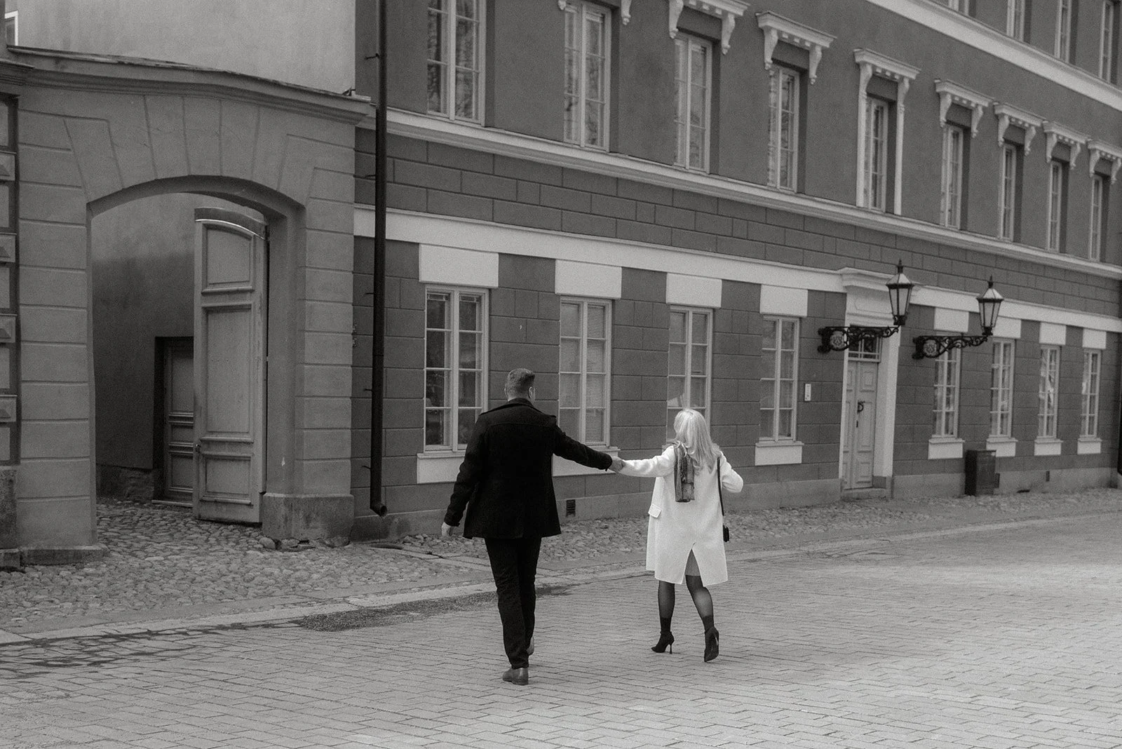 Pariskunta keskustelee kävellessään kaupungin kadulla. Pariskuntakuvaus Helsinki.