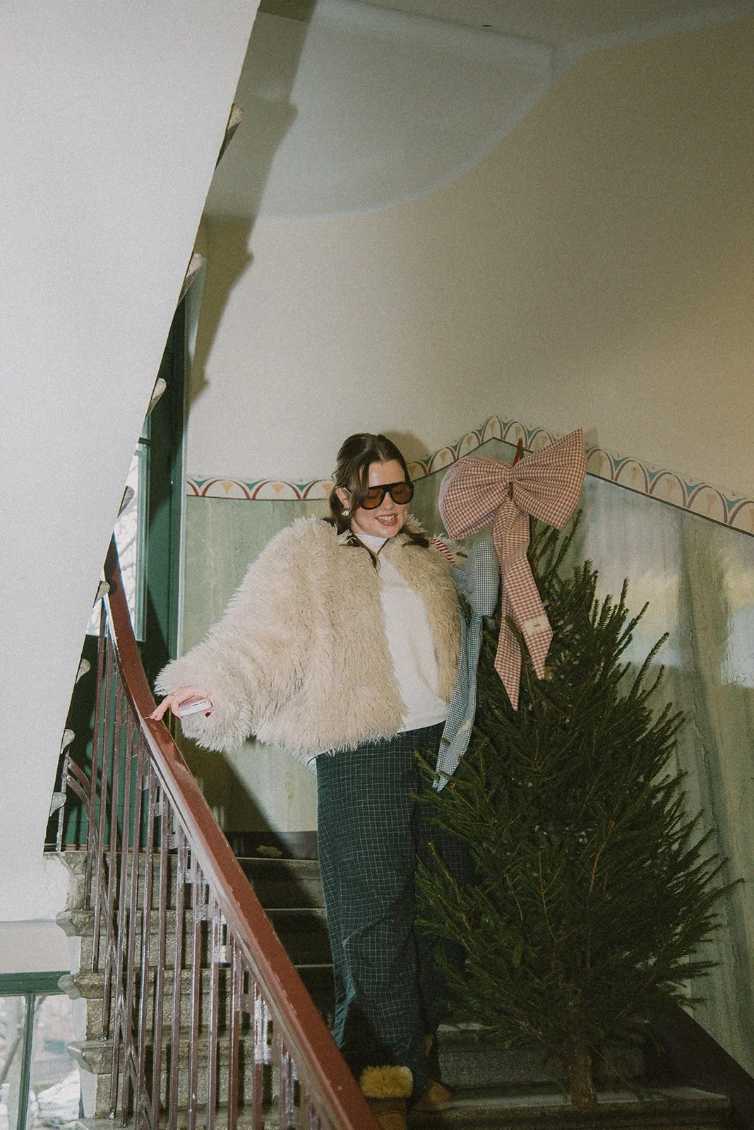 Edlan brändikuvaus Helsingissä, yrittäjä kantaa joulukuusta porraskäytävässä.