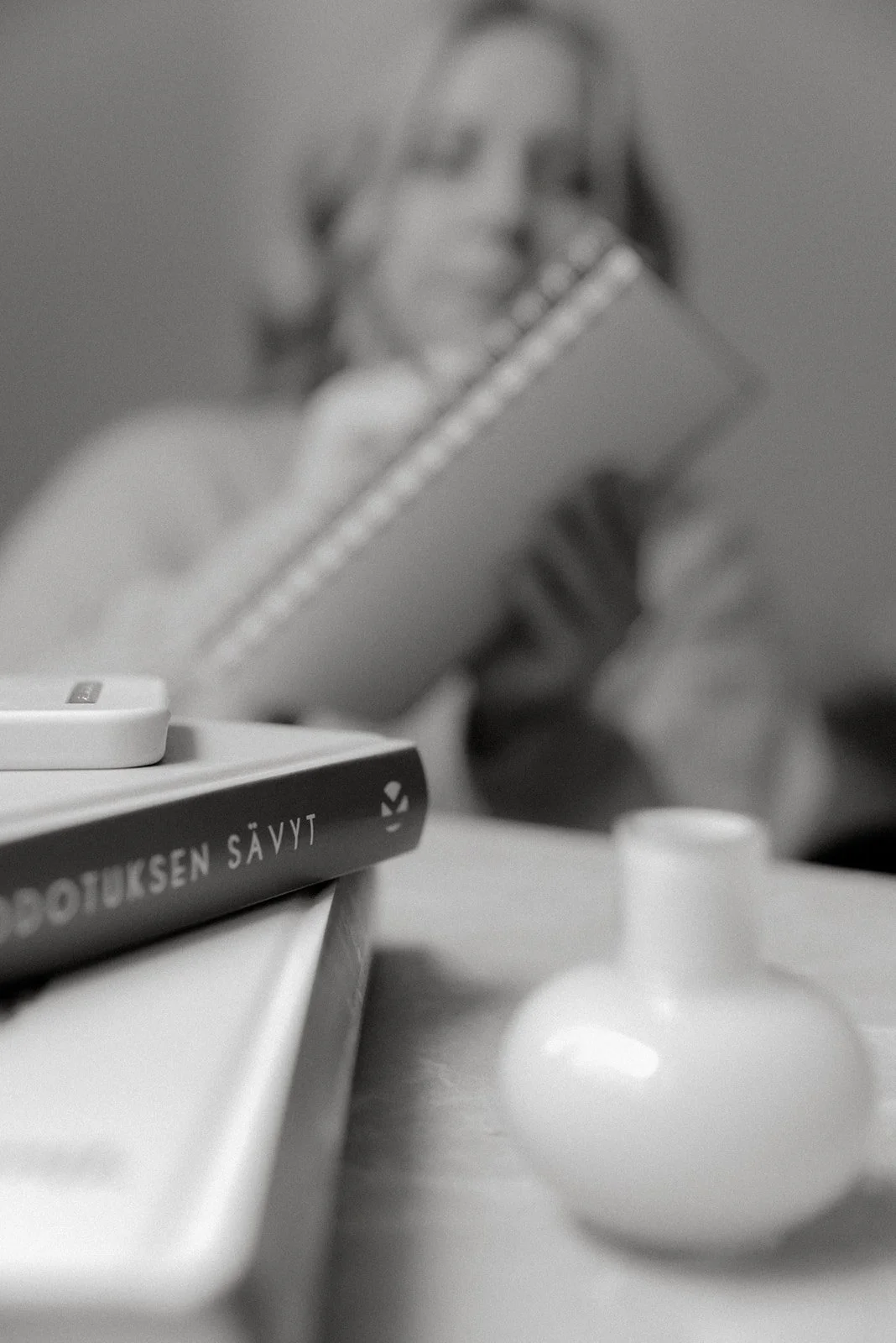 Mustavalkoinen henkilökuva. Naisyrittäjä kirjoittaa muistivihkoonsa.