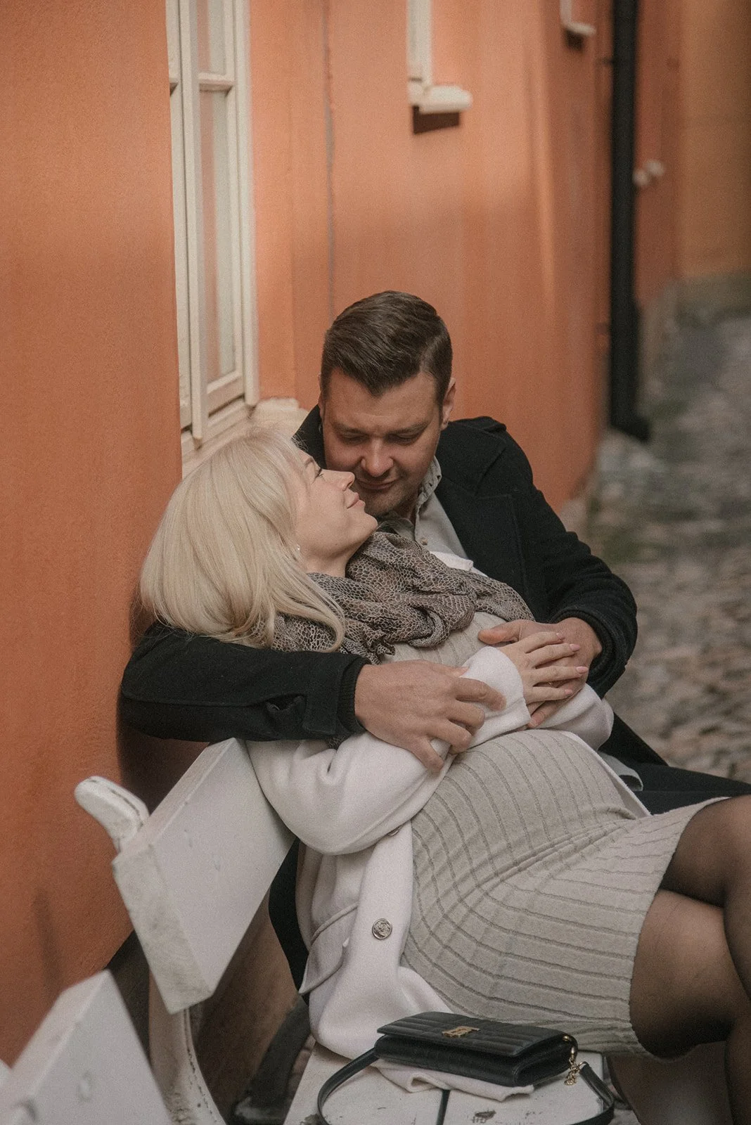 Odottava äiti miehen lempeässä syleilyssä. Pariskuntakuvaus Kerava.