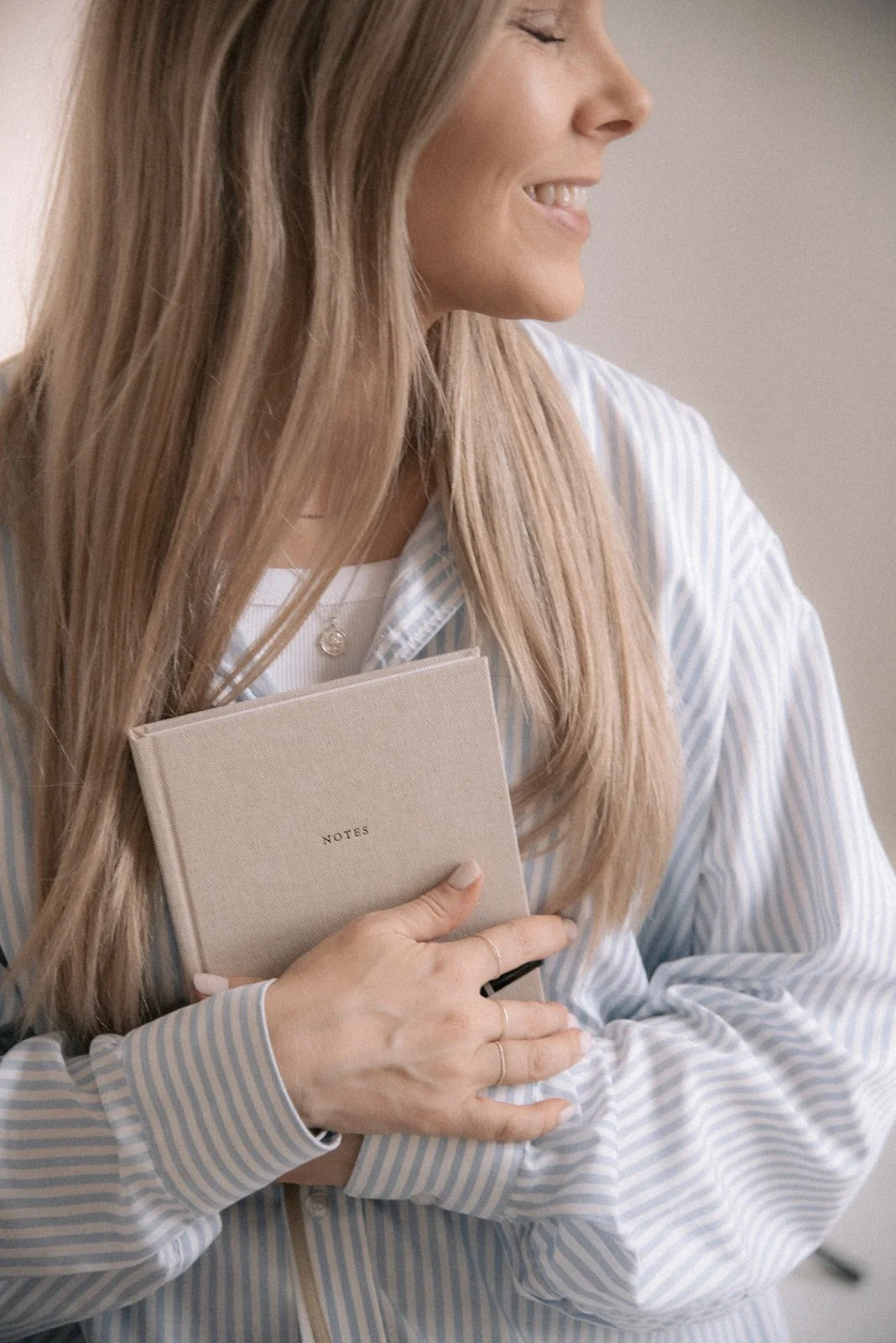 Heartiven brändikuvaus, yrittäjä Terhi Lahti pitelee sylissään muistikirjaa.