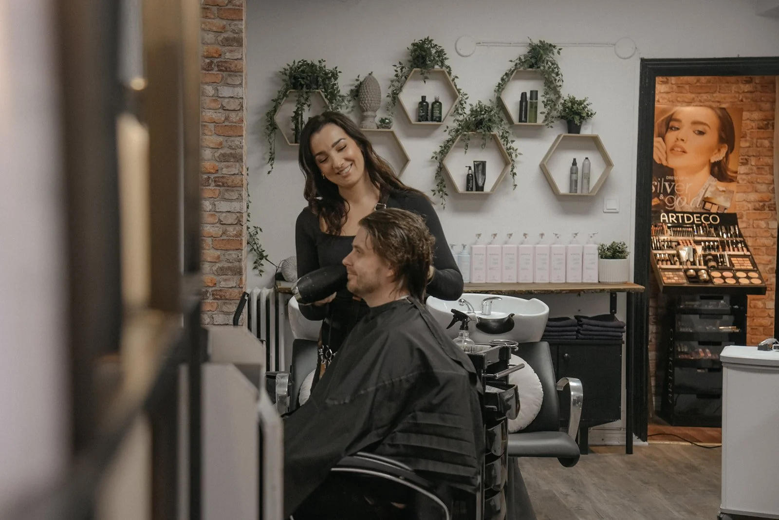 Hykken brändikuvaus, iloinen kampaaja työssään asiakkaan vierellä.