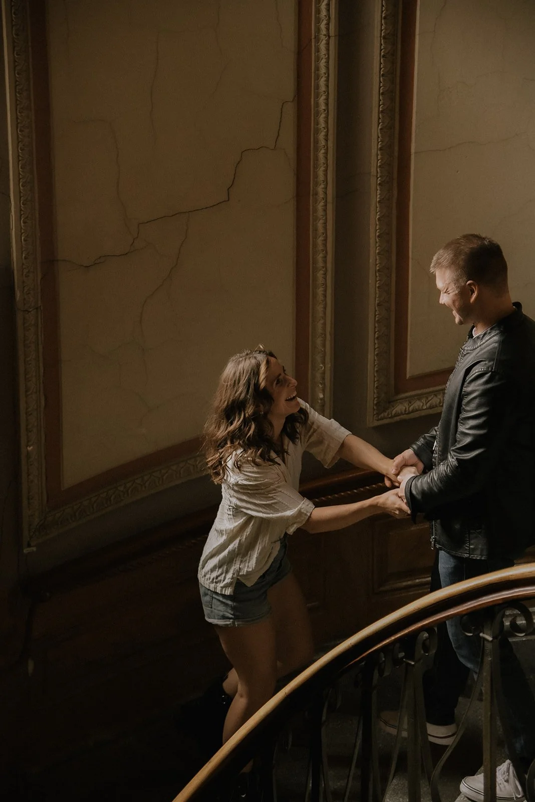 Pariskunta nauraa yhdessä kauniissa portaikossa. Pariskuntakuvaus Helsinki.