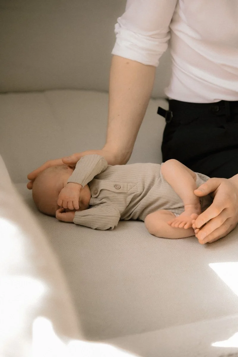 Vauva makaa sohvalla luonnonvalossa. Vauvakuvaus Espoo. 